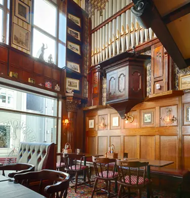 Pub environment with high ceilings, seating and lots of decorations