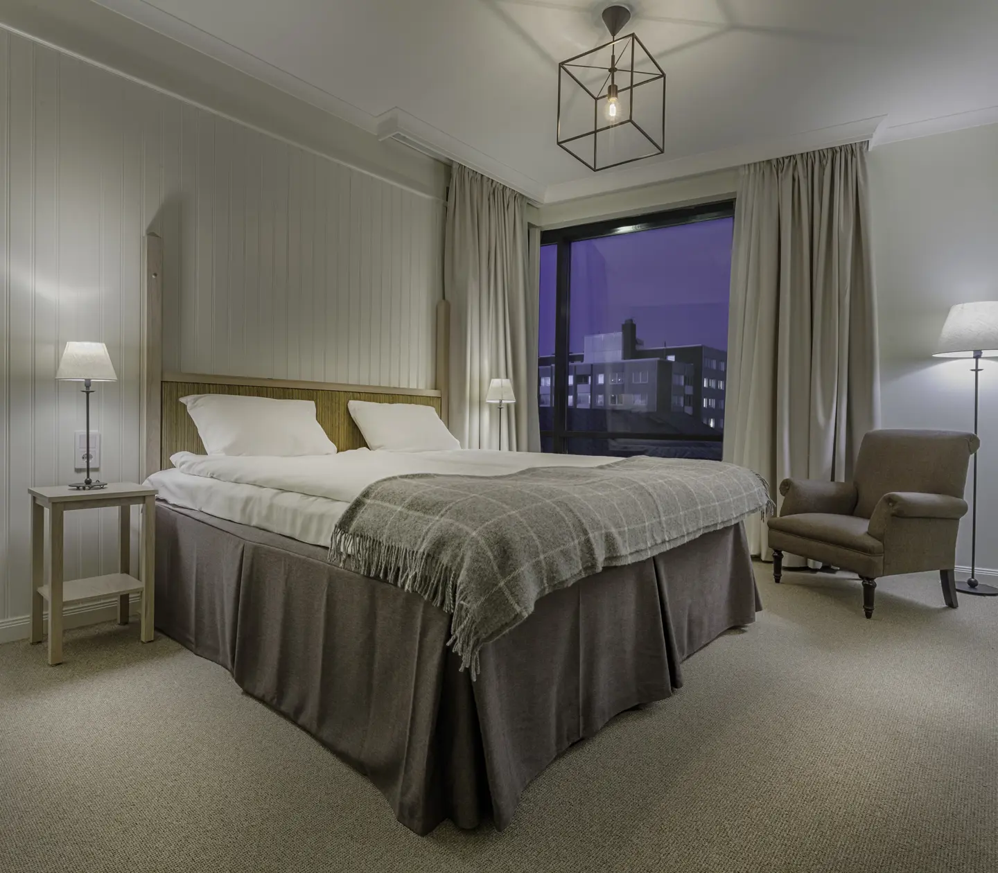 Cozy hotel room with bed, armchair and window