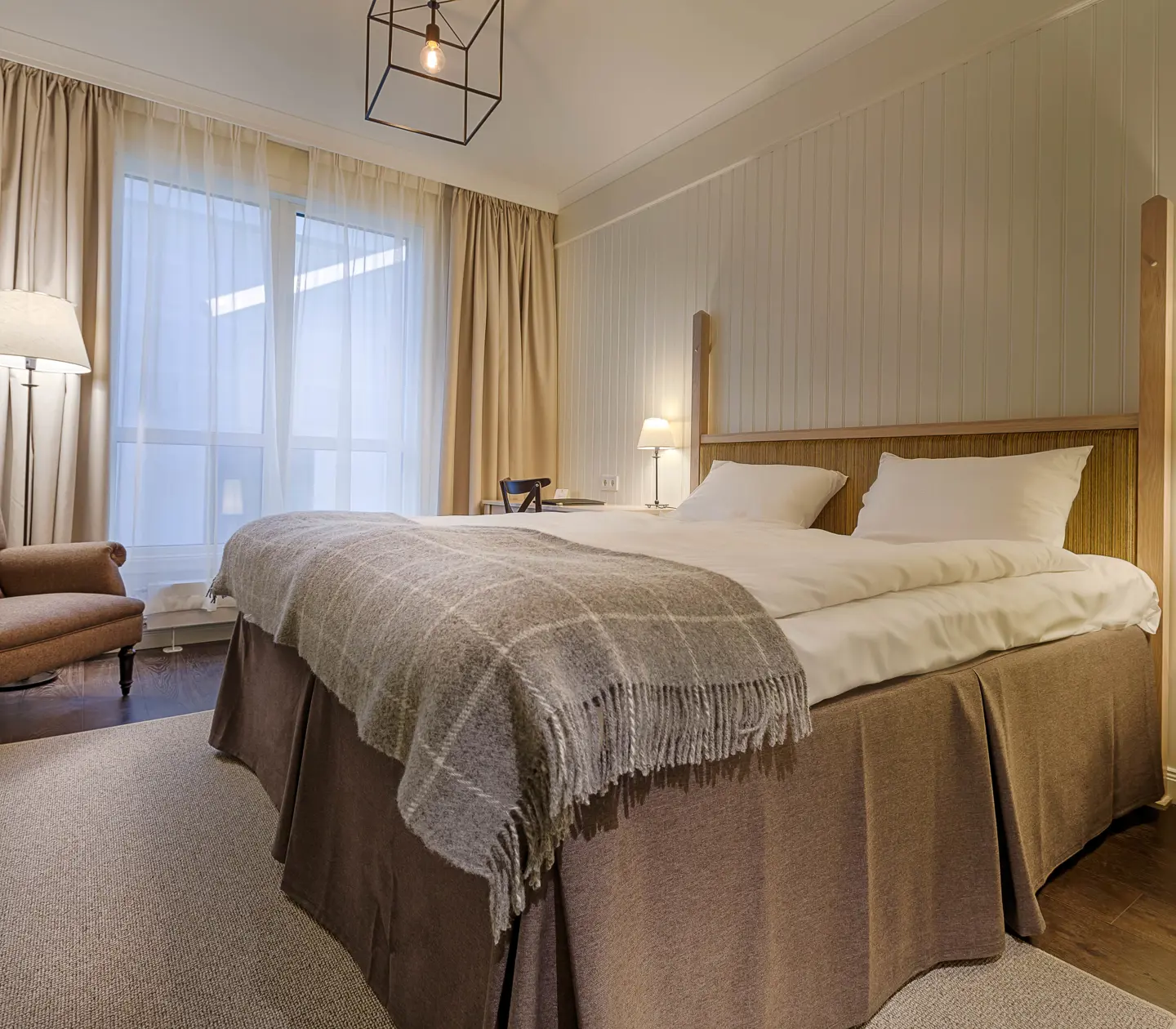 Cozy hotel room with bed, armchair and window