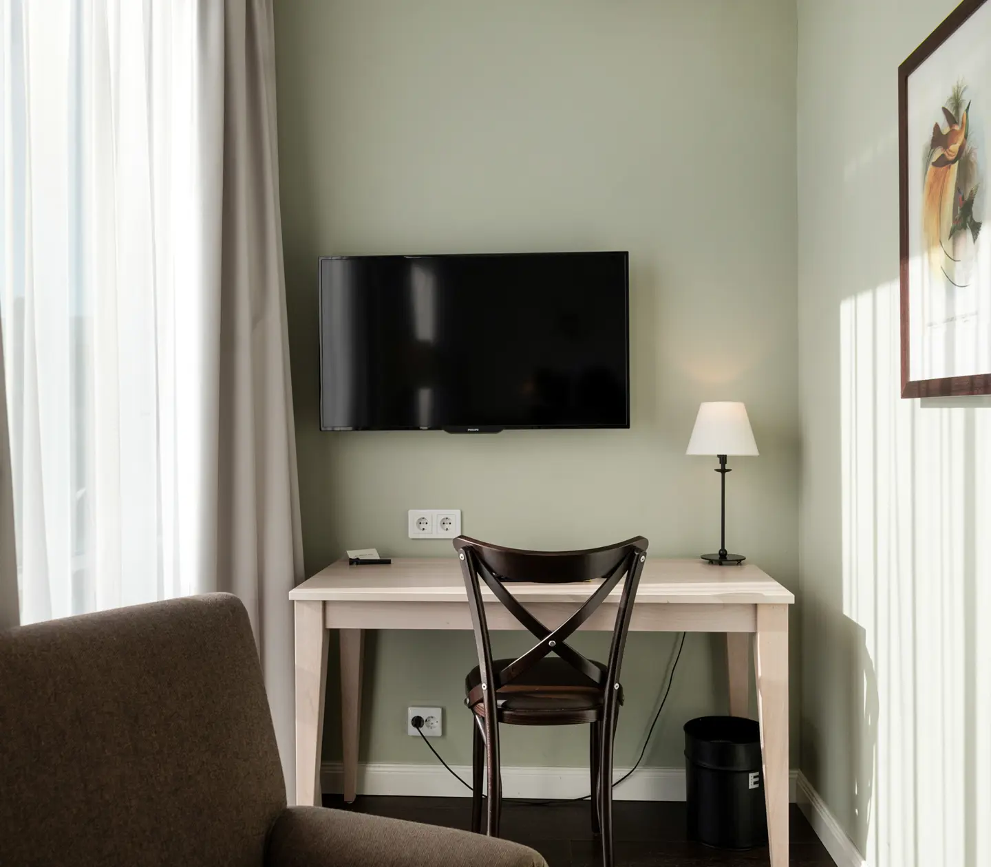 Cozy hotel room with desk, armchair and TV