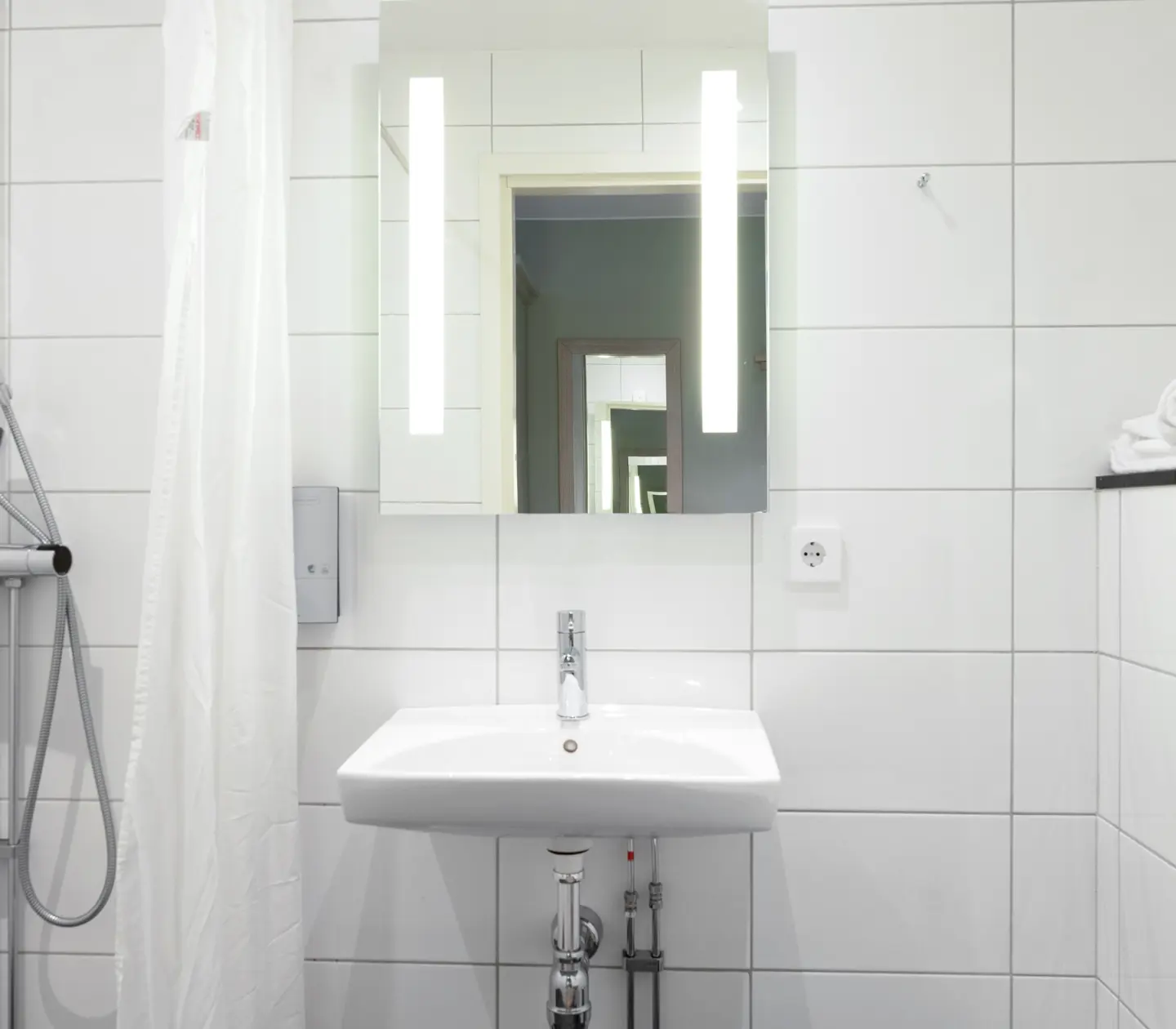 Bright bathroom with shower, sink and mirror