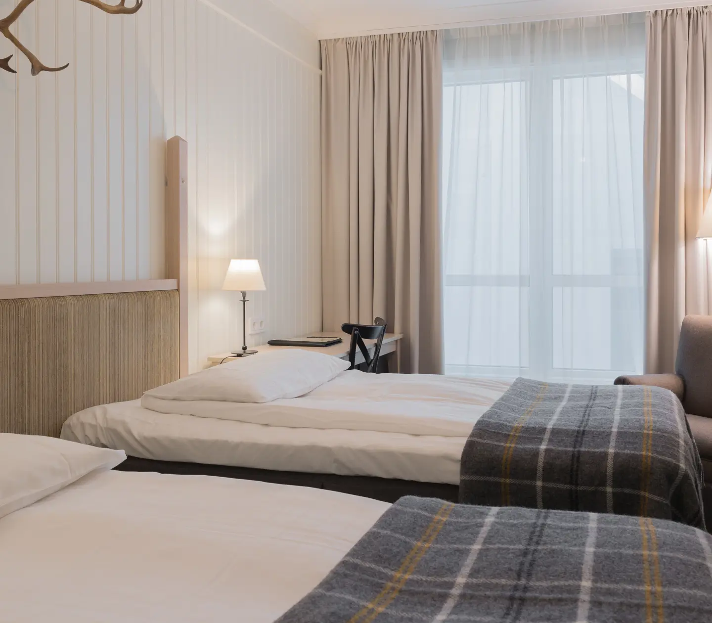 Cozy hotel room with separate beds, window and armchair