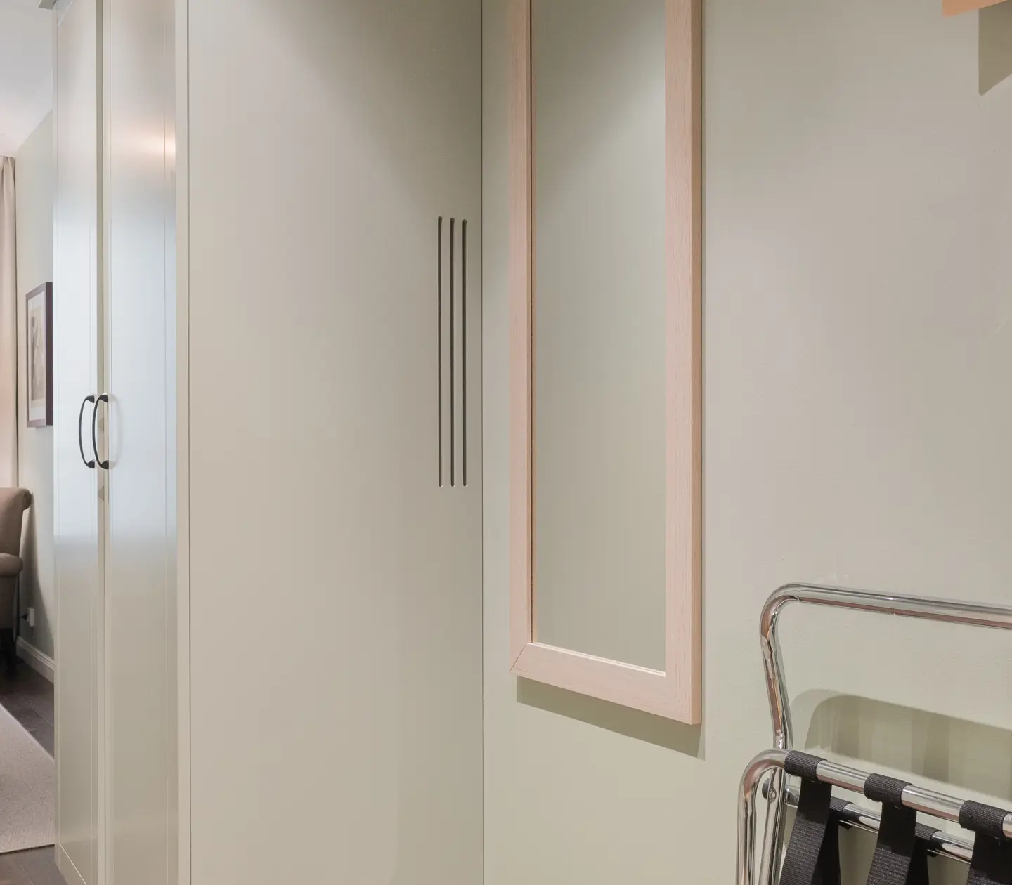Hotel room with clothes hanger, mirror and wardrobe