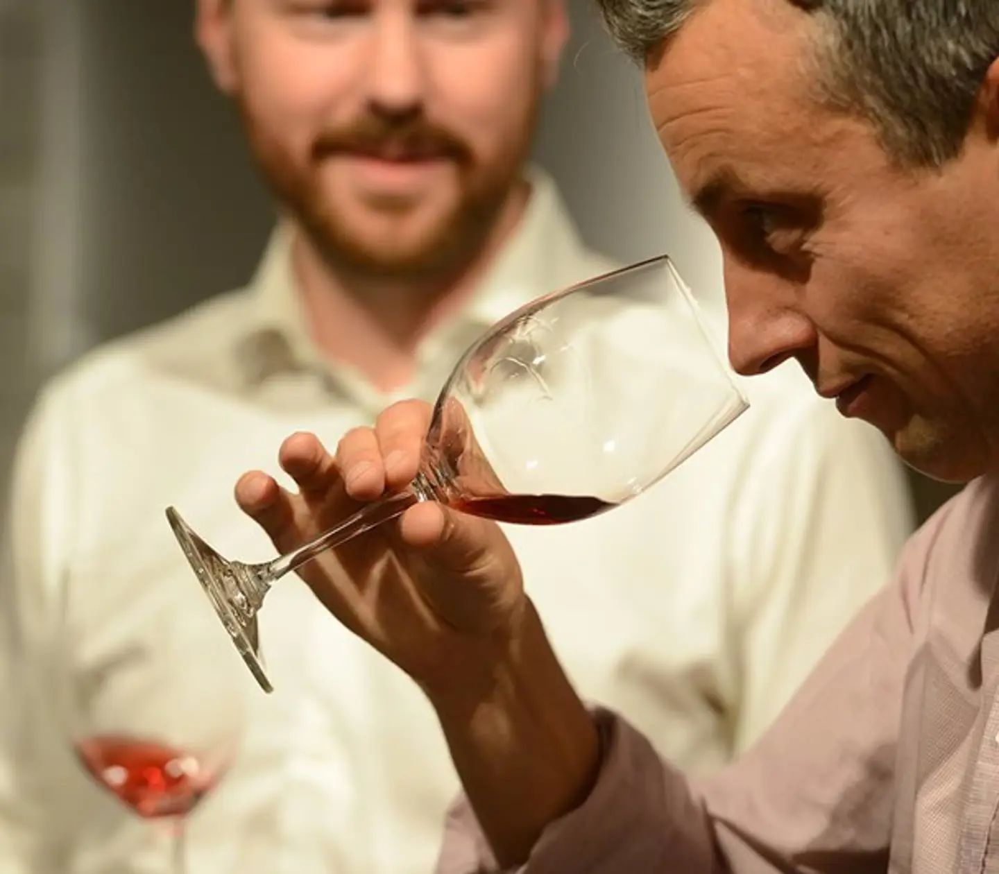 Man closing his eyes and smelling wine in a wine glass