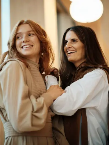 Two women holding each other in a hotel environment