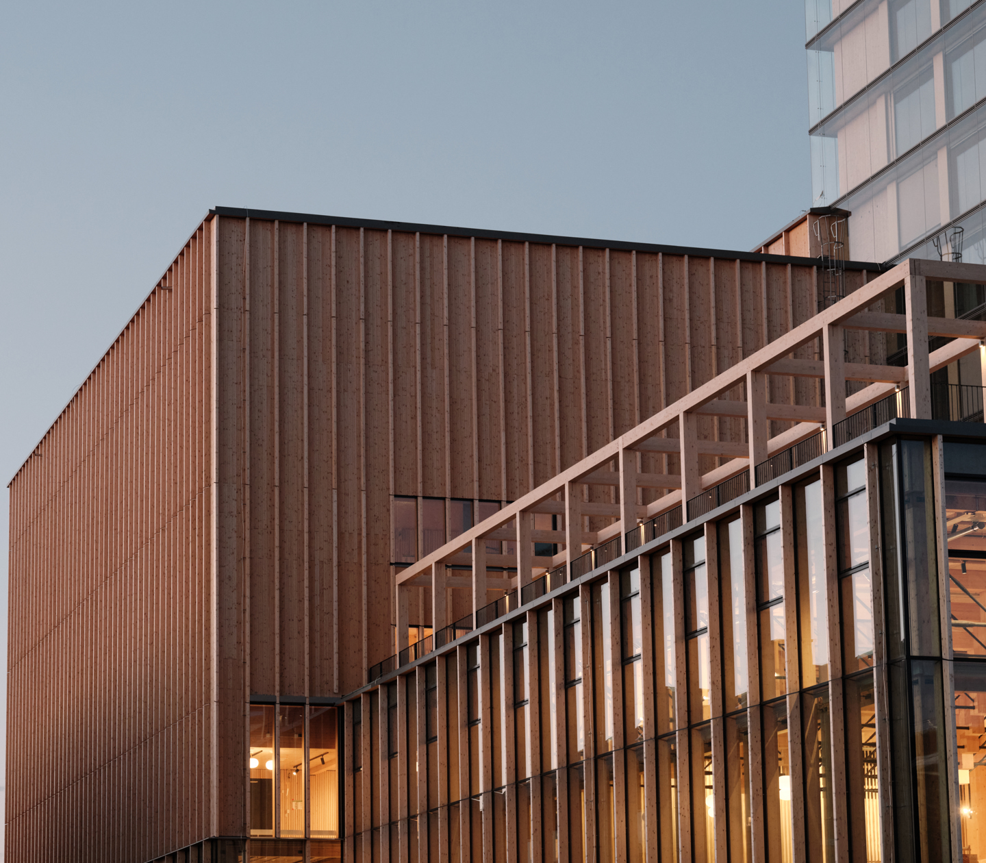 The facade of The Wood Elite by Elite at dusk with indoor lights on