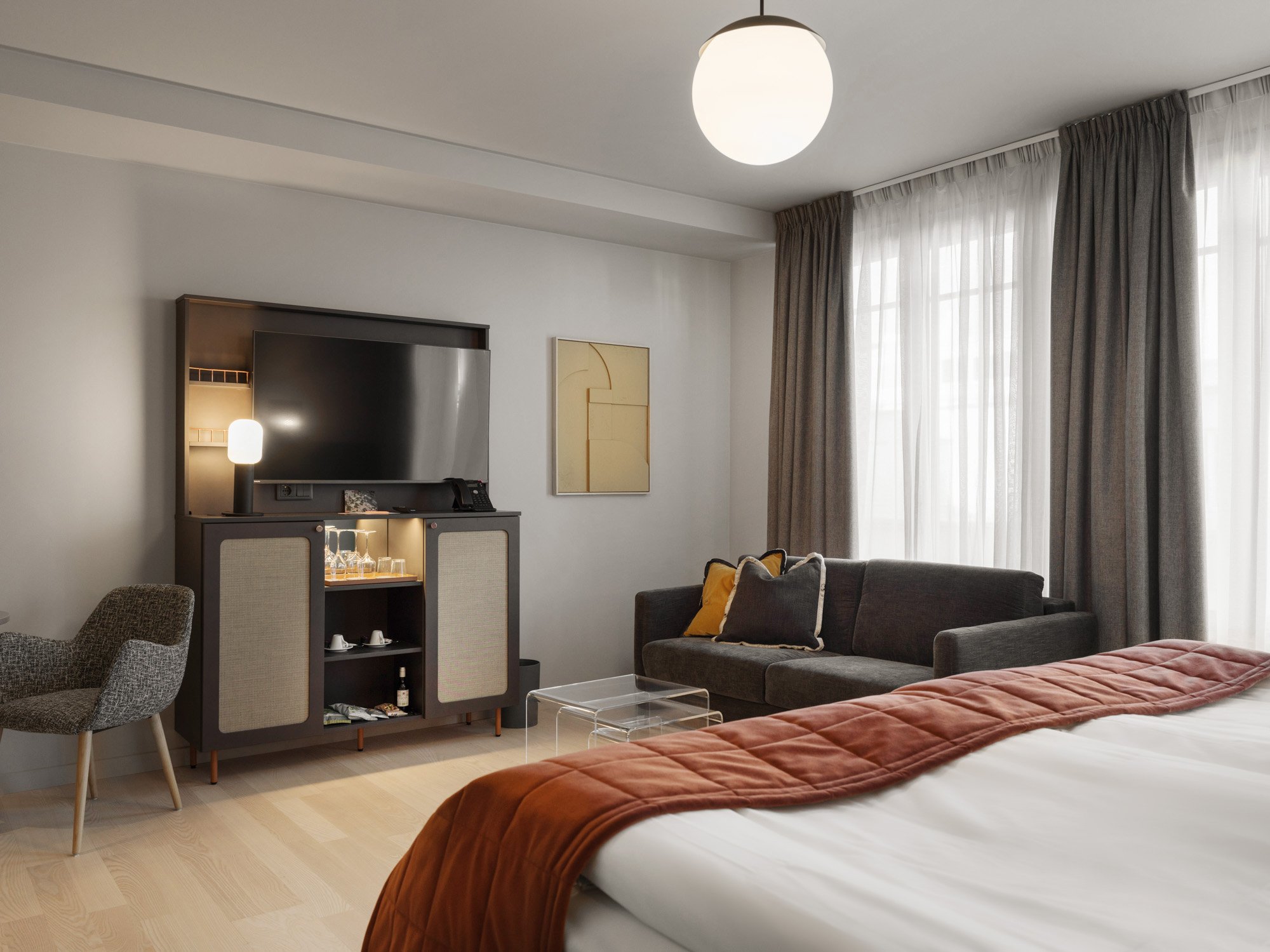 Mysigt hotellrum med säng, soffa och tv