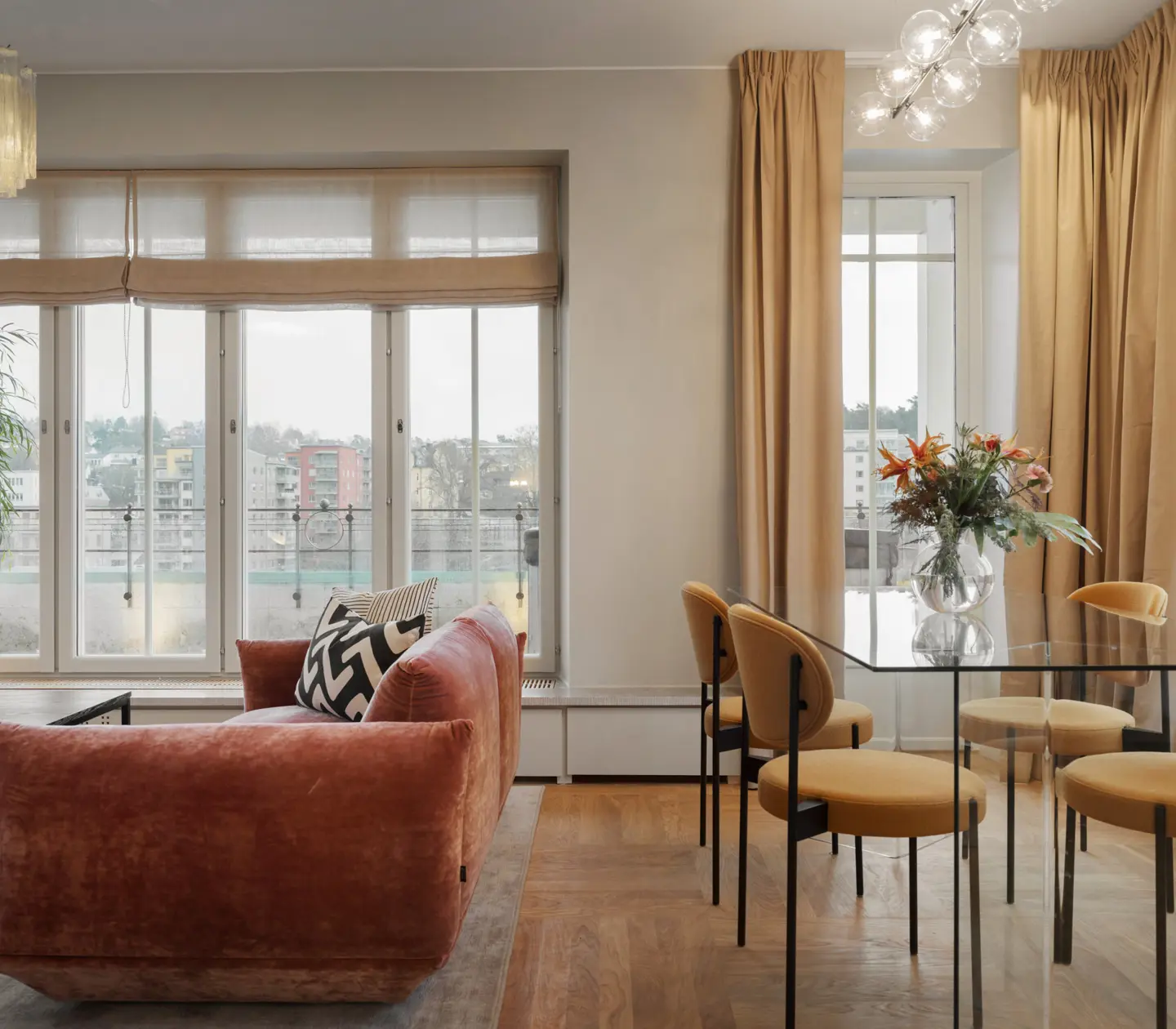 Svit med rosa soffa, matbord och stora fönster