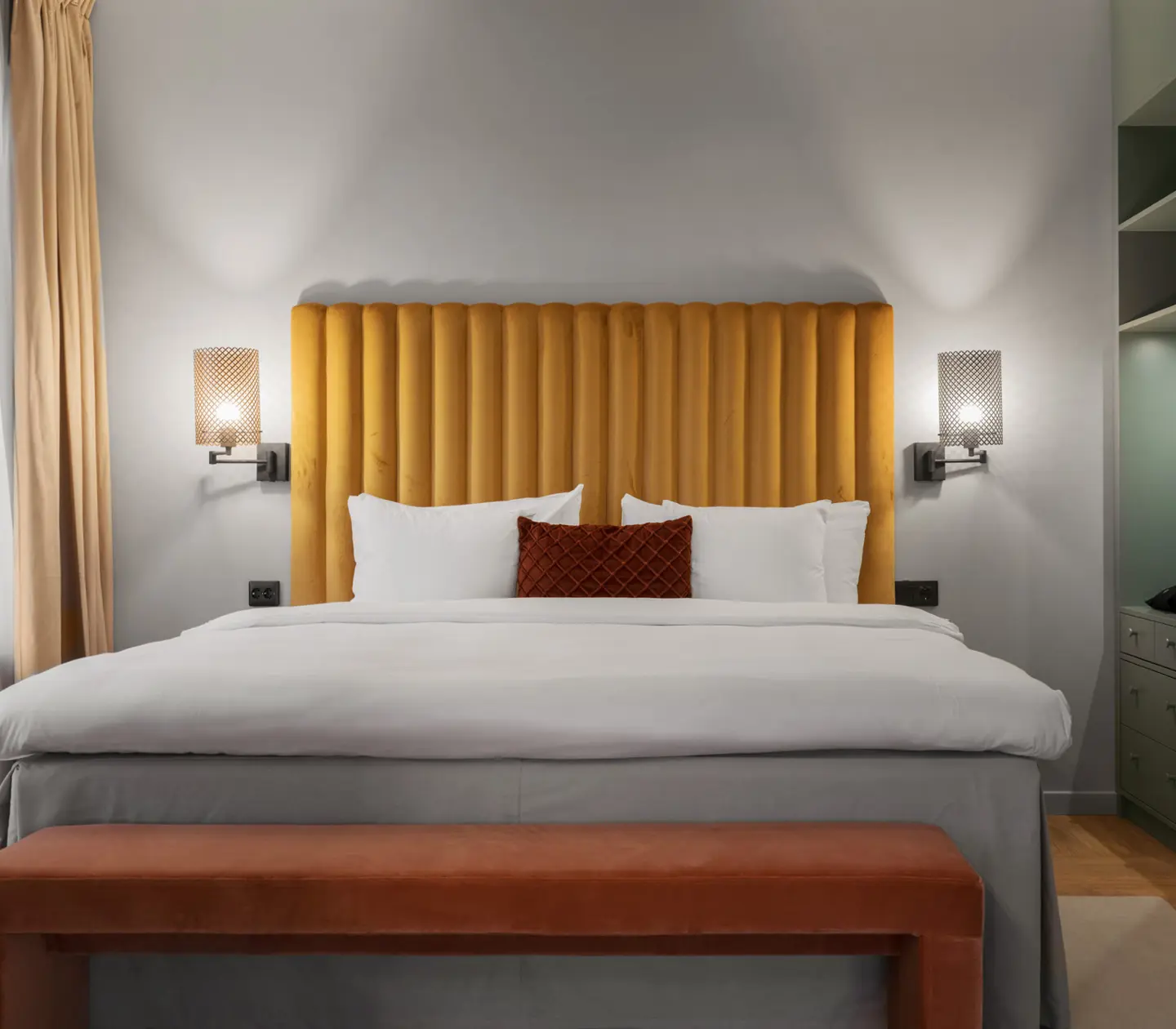 Svit med soffa, gul sänggavel och sänglampor