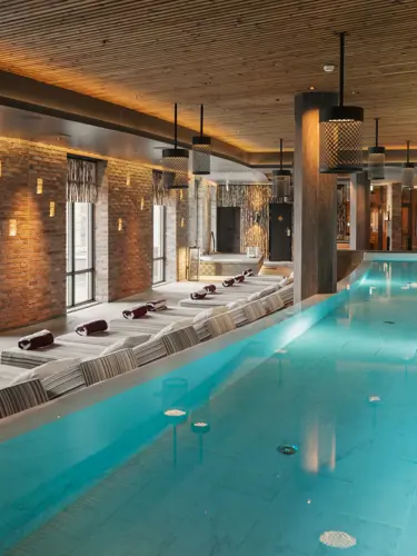 Spa environment with large pool, many sunbeds and large windows