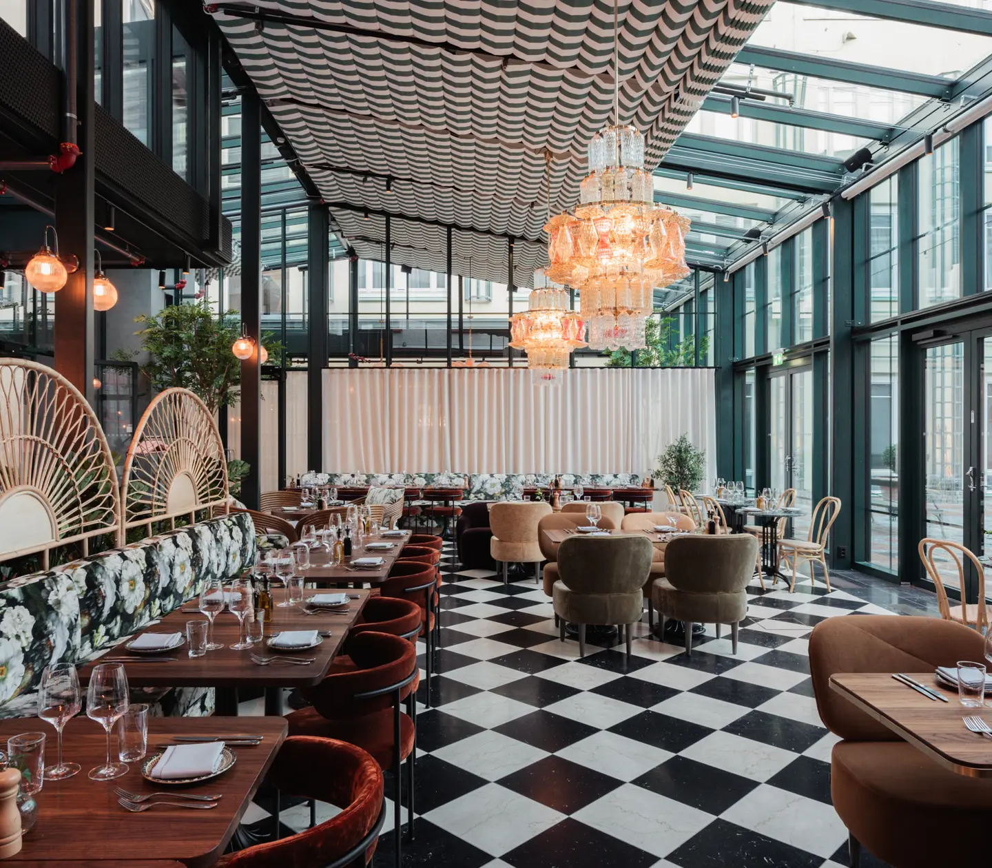Restaurangmiljö med schackrutat golv, matgrupper och stora fönster