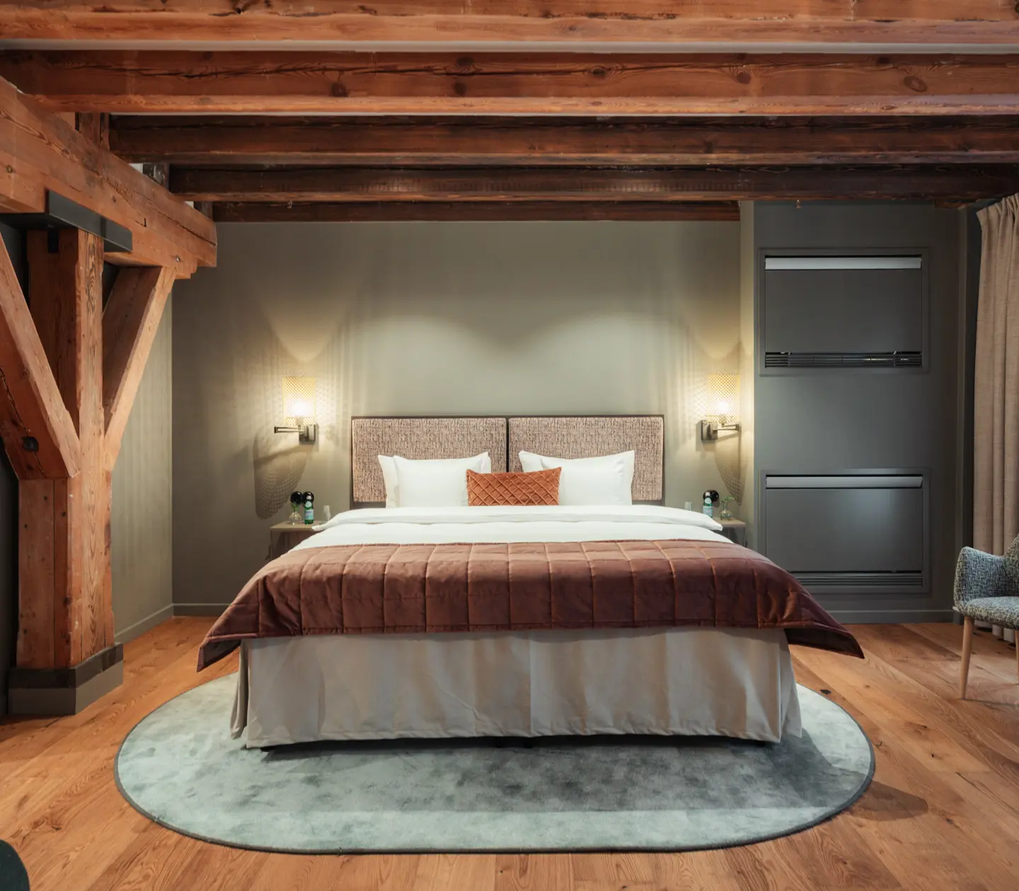 Mysigt hotellrum med träbalkar i taket, hotellsäng och fönster
