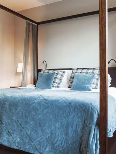 Svit med dubbelsäng med blått överkast