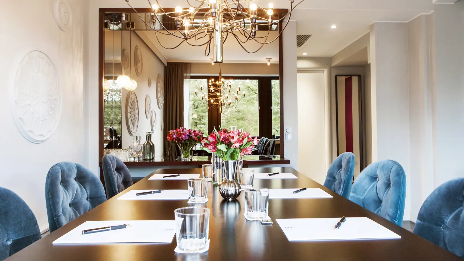 Board room with dark brown table, blue chairs and white walls