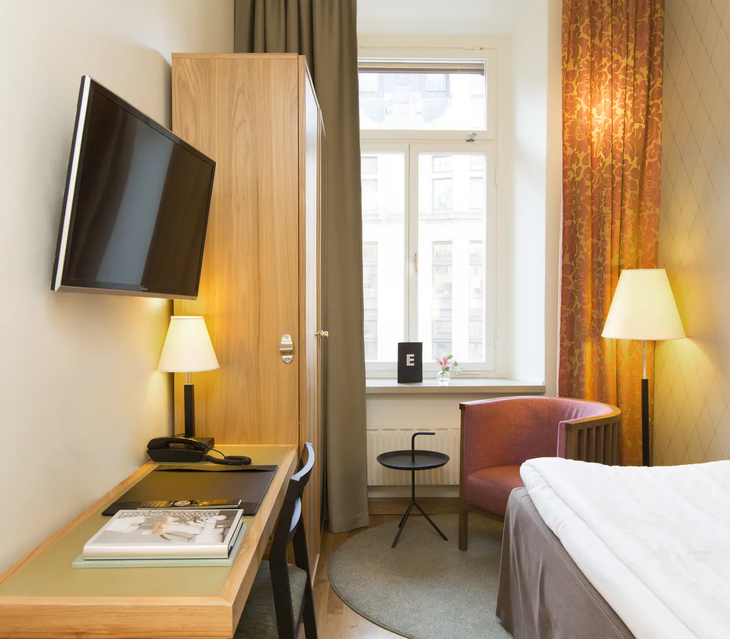 Hotel room with single bed, desk and armchair