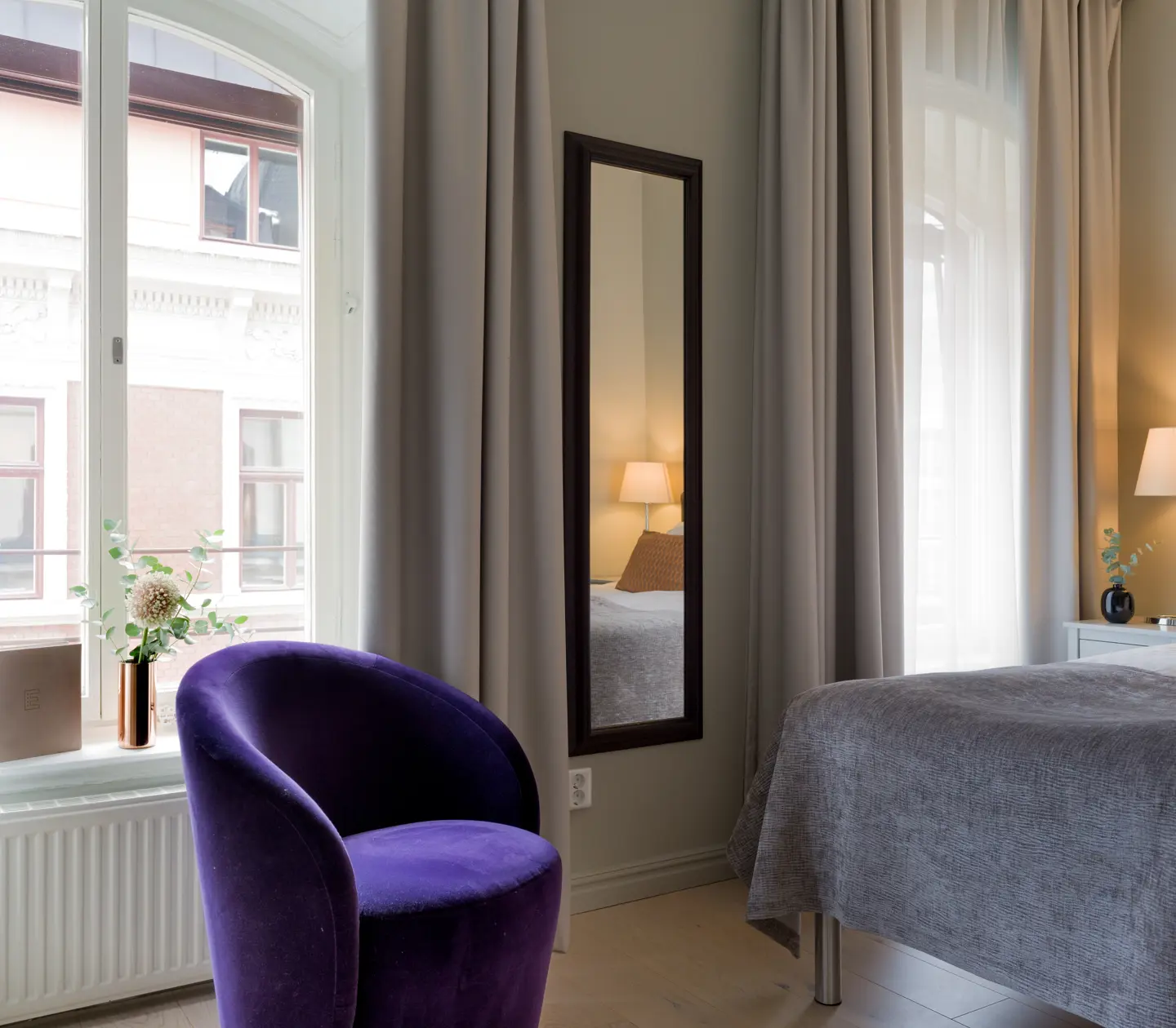 A double bed and a purple armchair