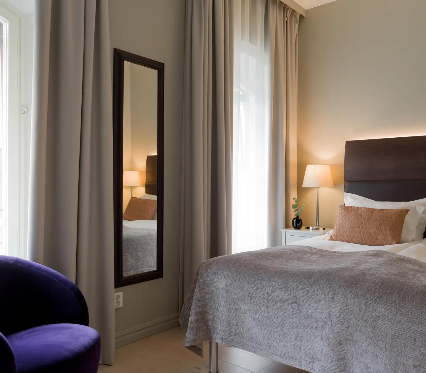 A double bed and a purple armchair