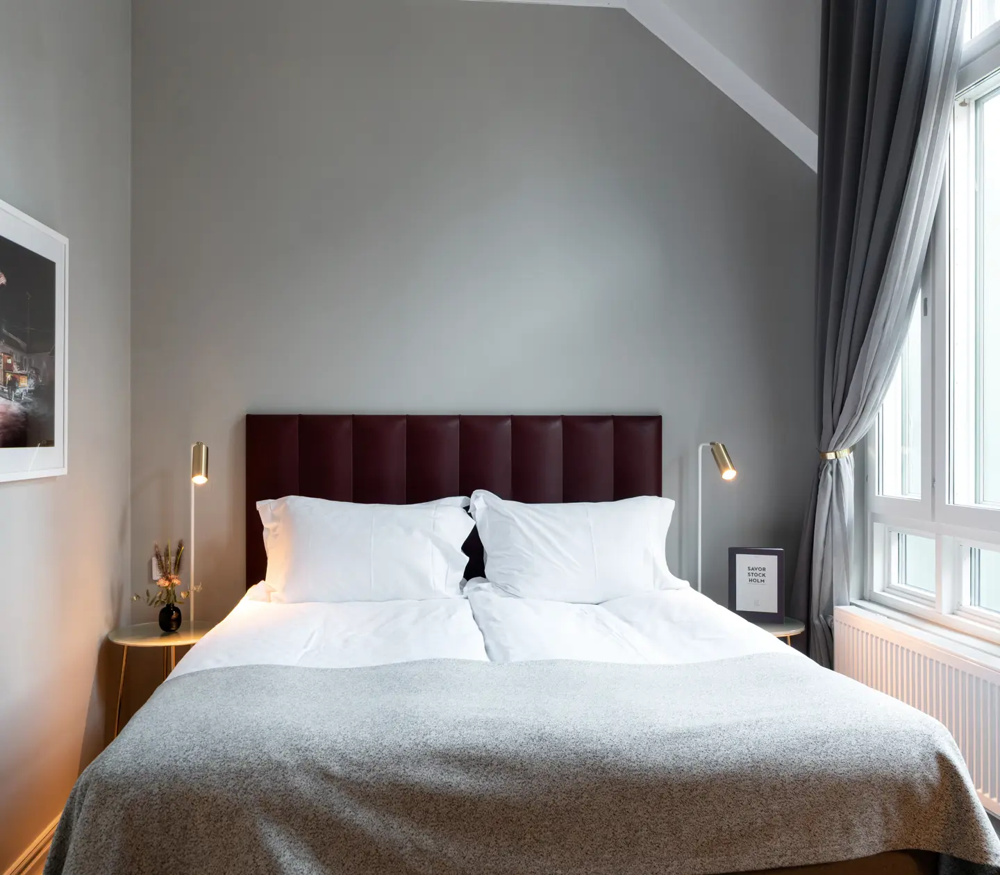 Room with large window and beautifully made double bed