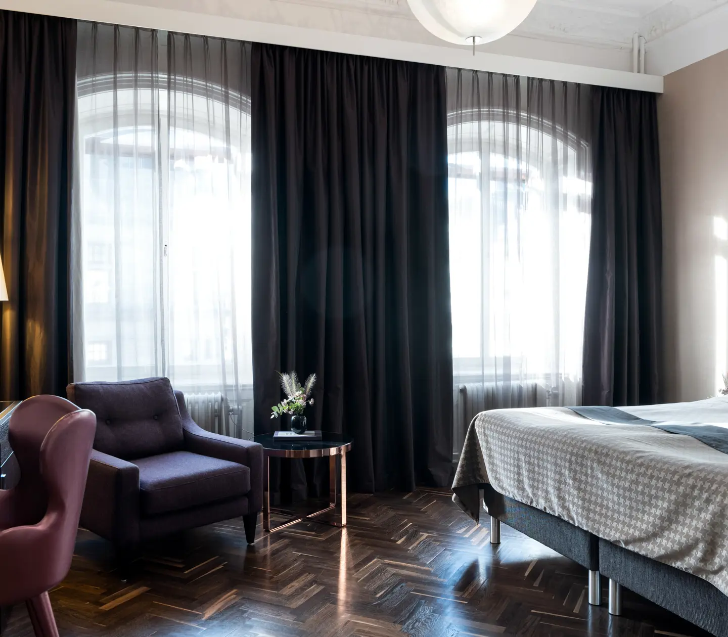 Room with beautiful light and double bed, desk and armchair