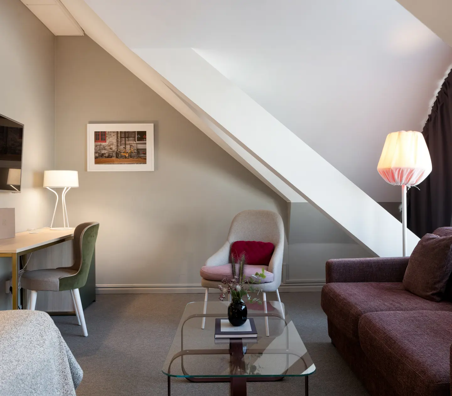 Room with slanted ceiling, sofa and desk
