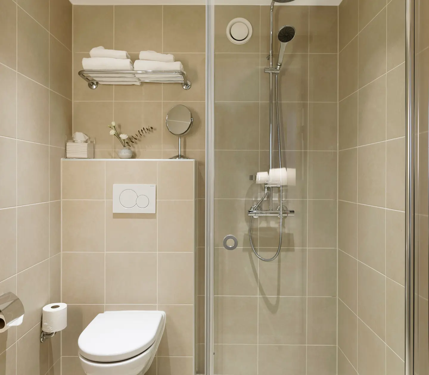 Beige bathroom with toilet, sink and shower