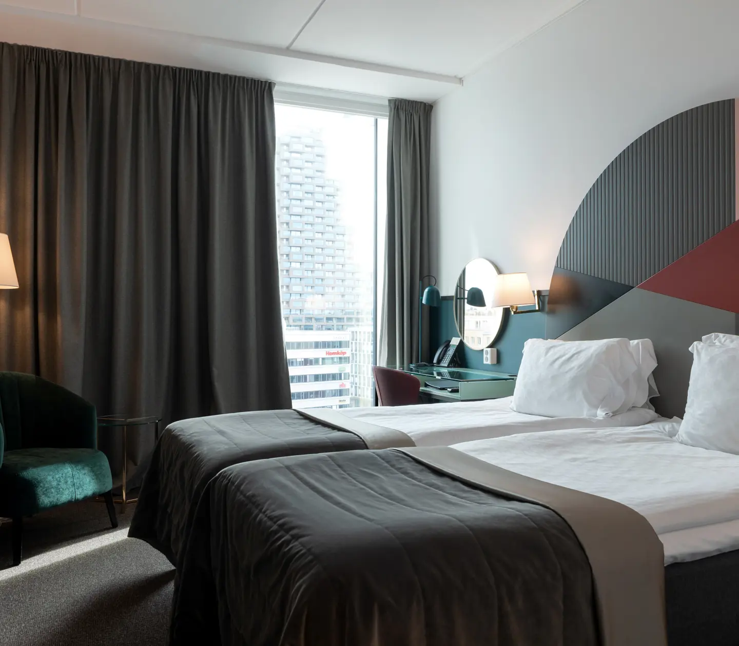 Bright hotel room with beds, colorful headboard and window