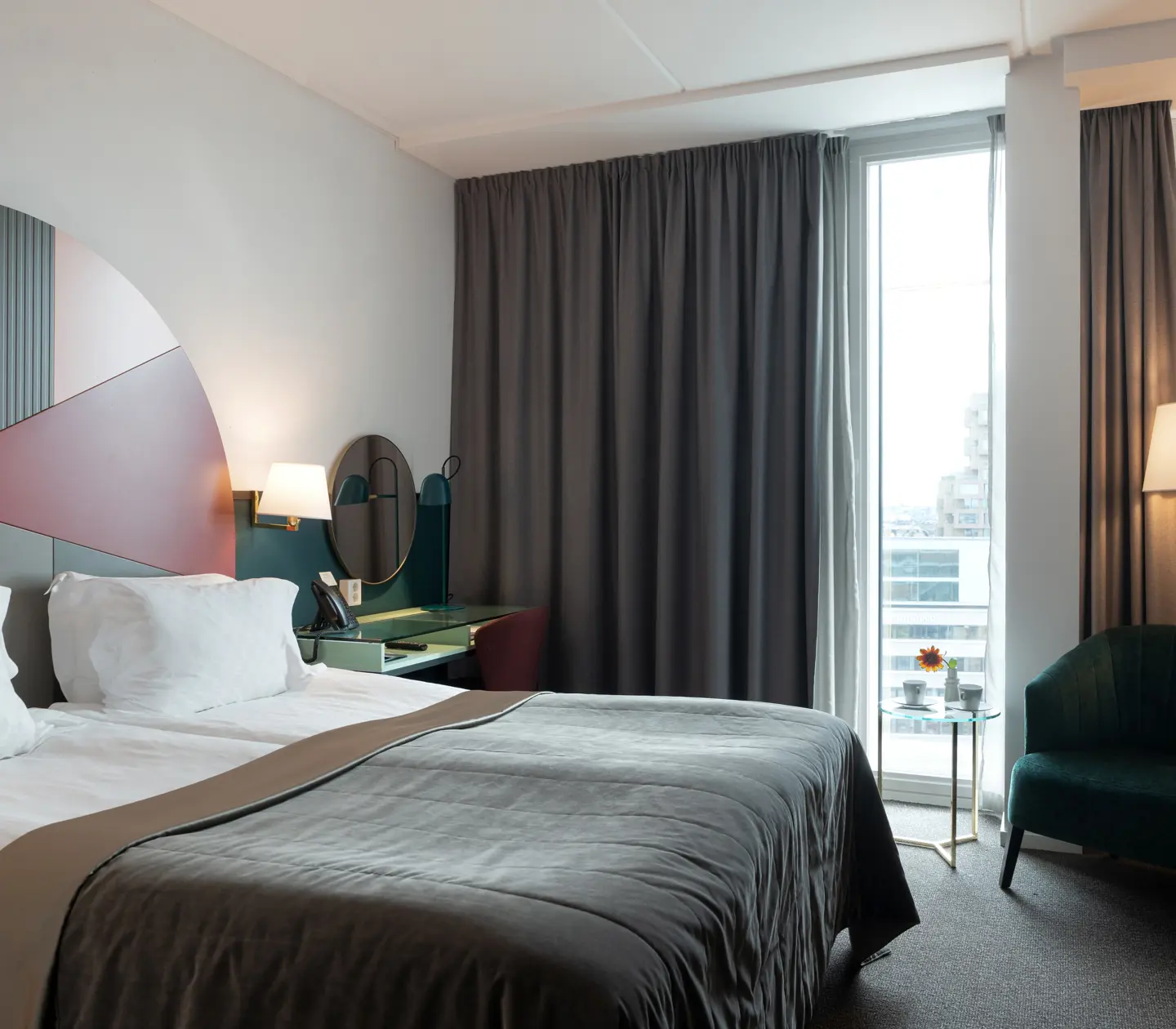 Bright hotel room with bed, colorful headboard and window
