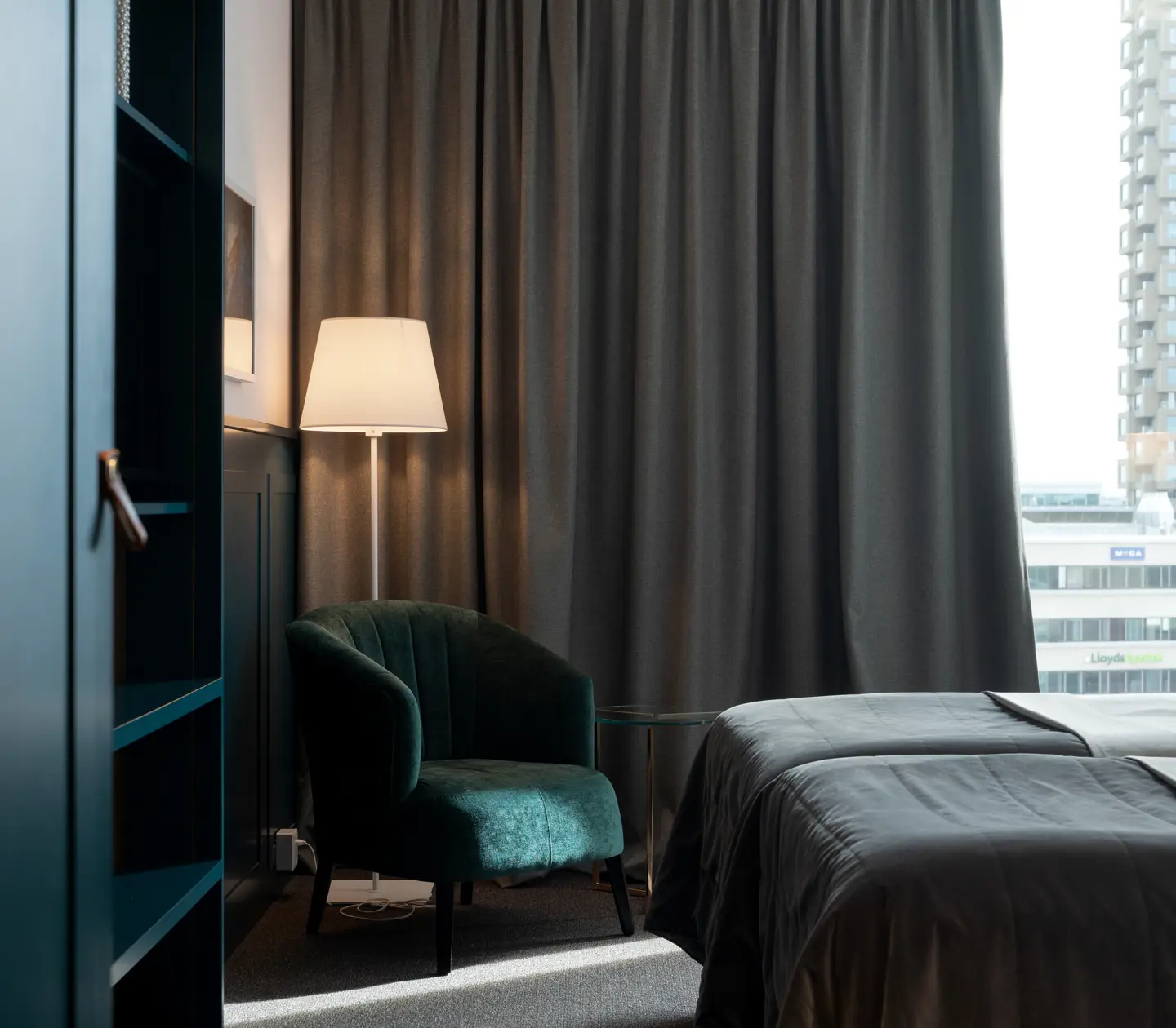 Bright hotel room with bed, armchair and large window