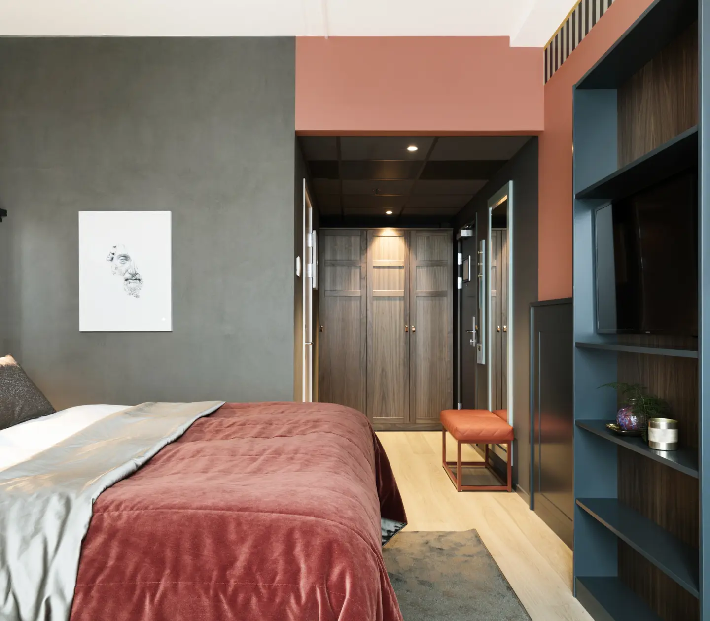 Cozy hotel room with bed, bookcase and wardrobe