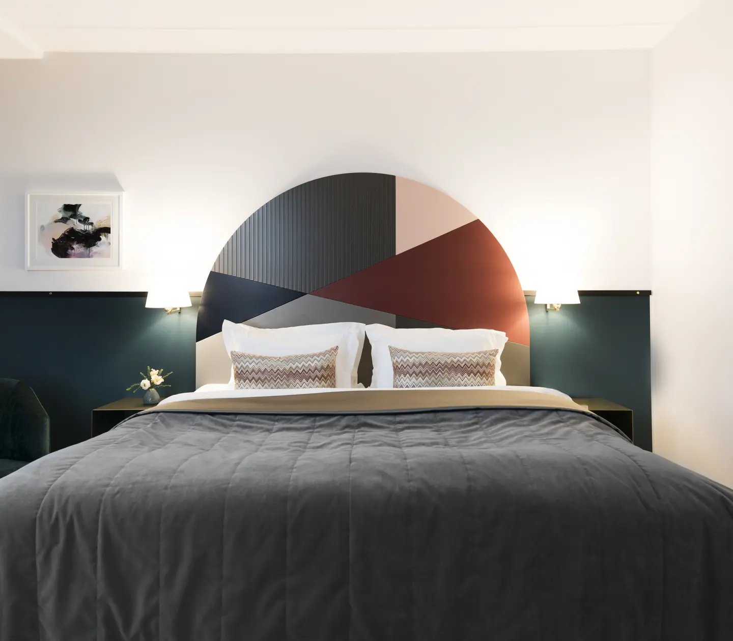 Bright hotel room with bed, colorful headboard and bedside lamps