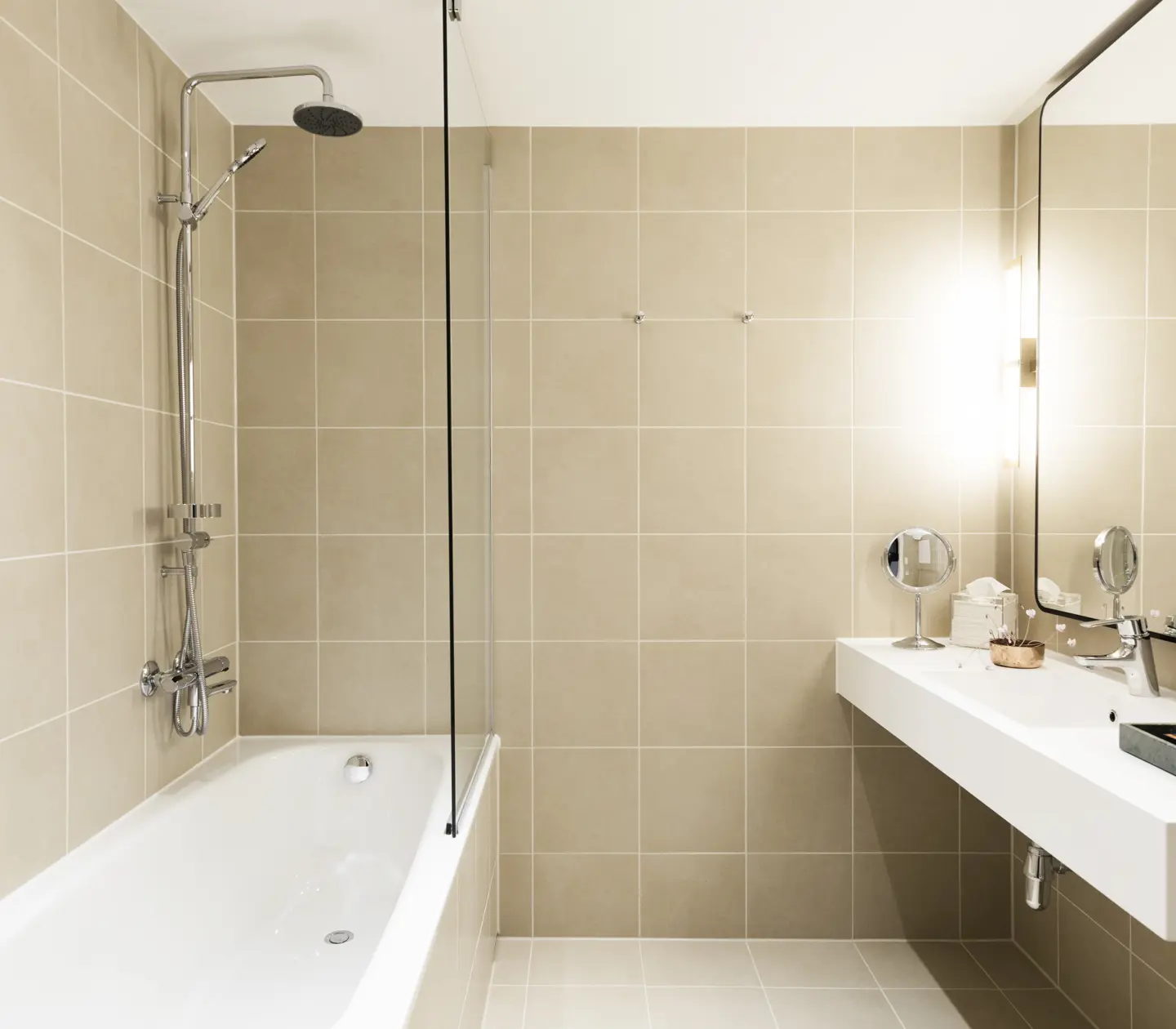 Beige bathroom with bathtub, sink and mirror