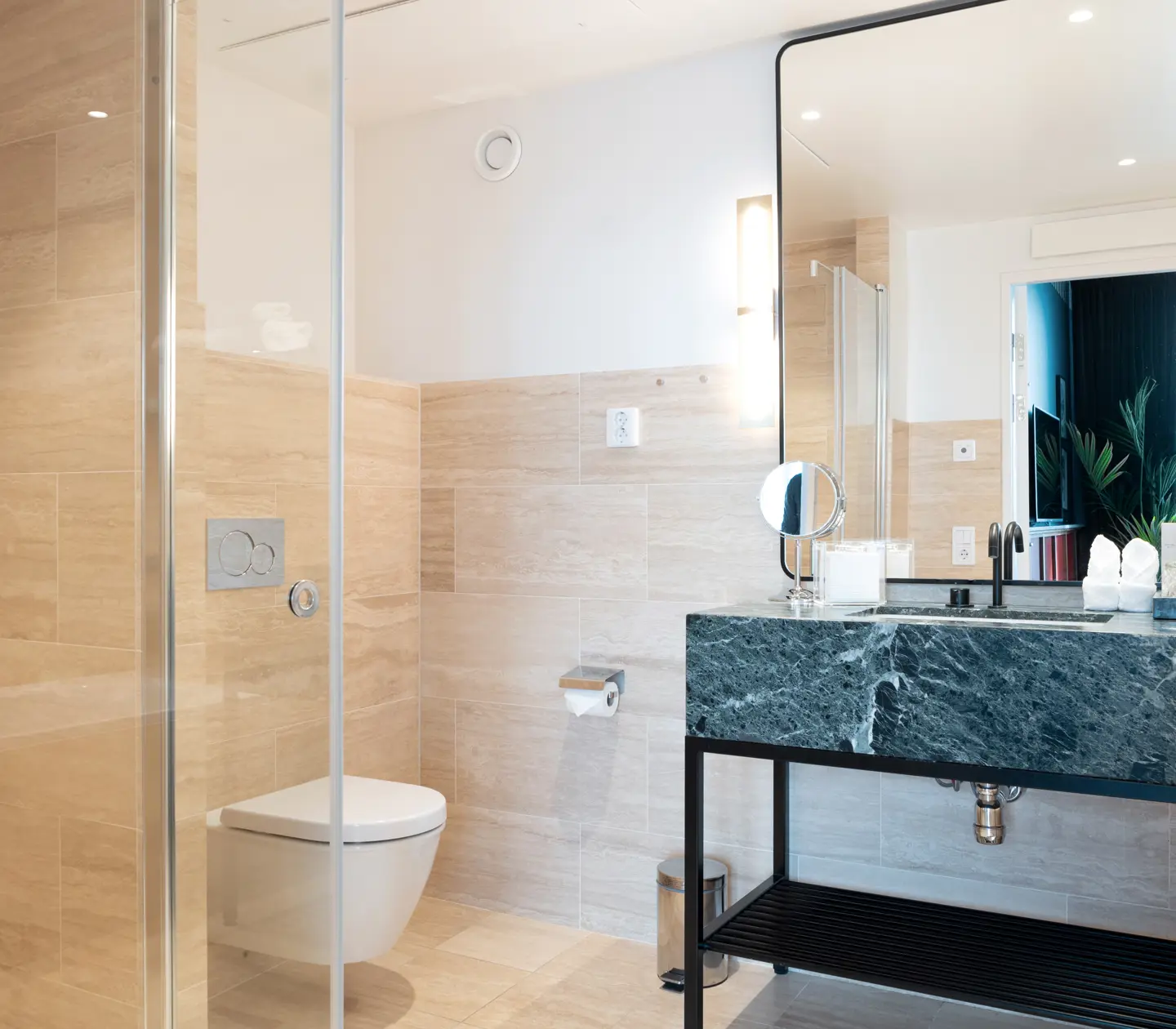 Beige bathroom with toilet, sink and mirror