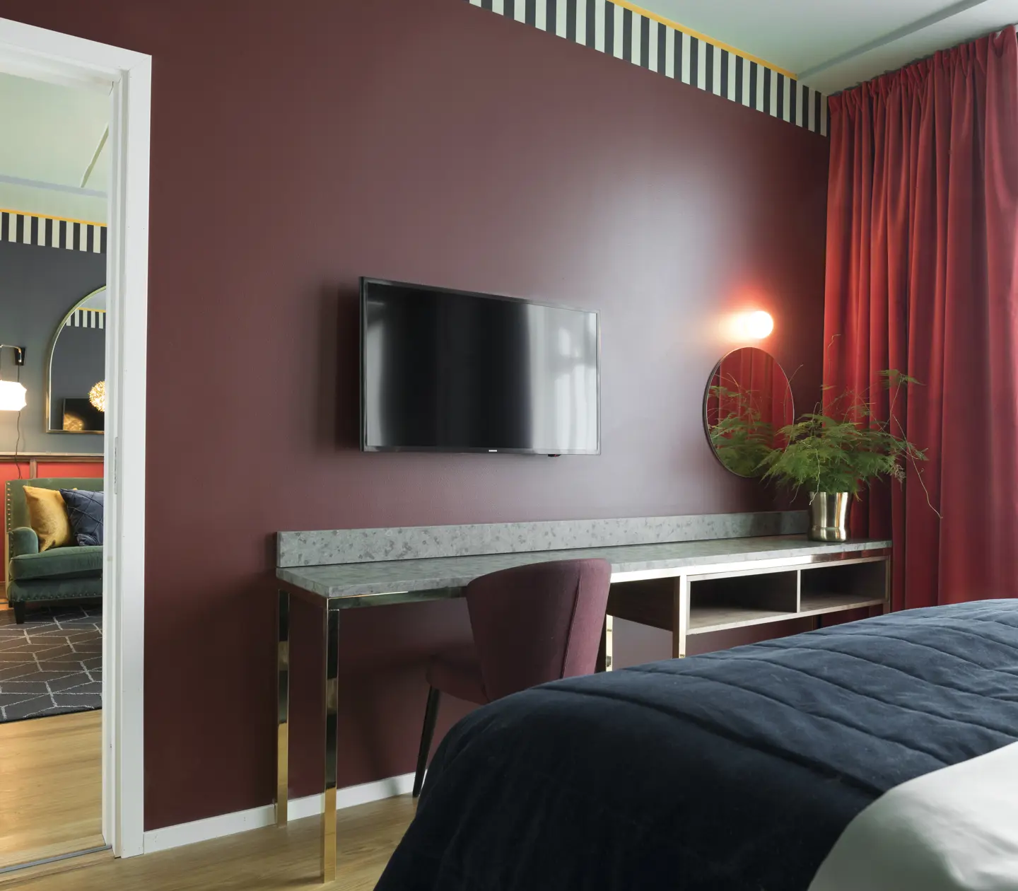 Cozy suite with dark red walls, desk and TV
