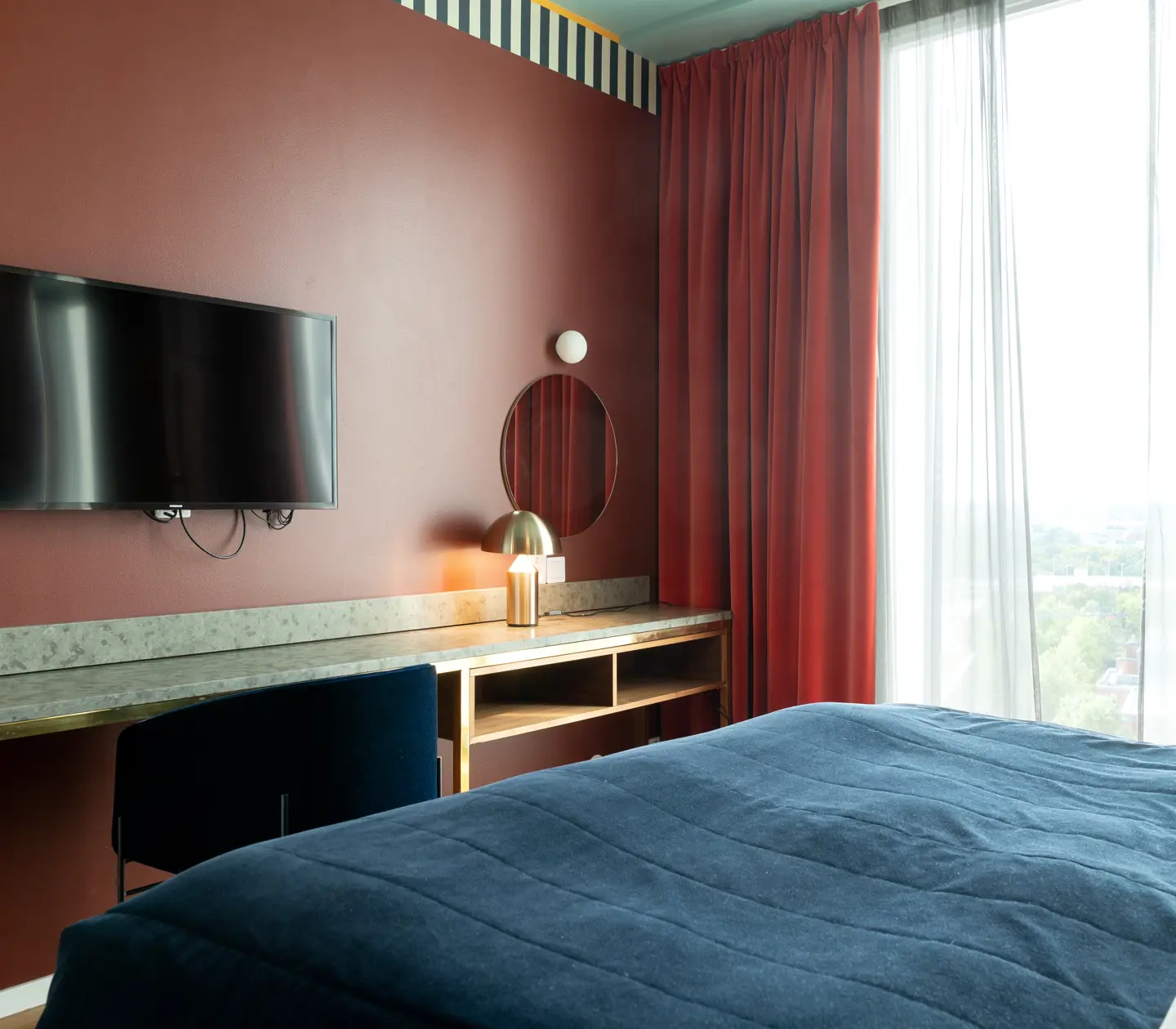 Cozy suite with dark red walls, desk and TV