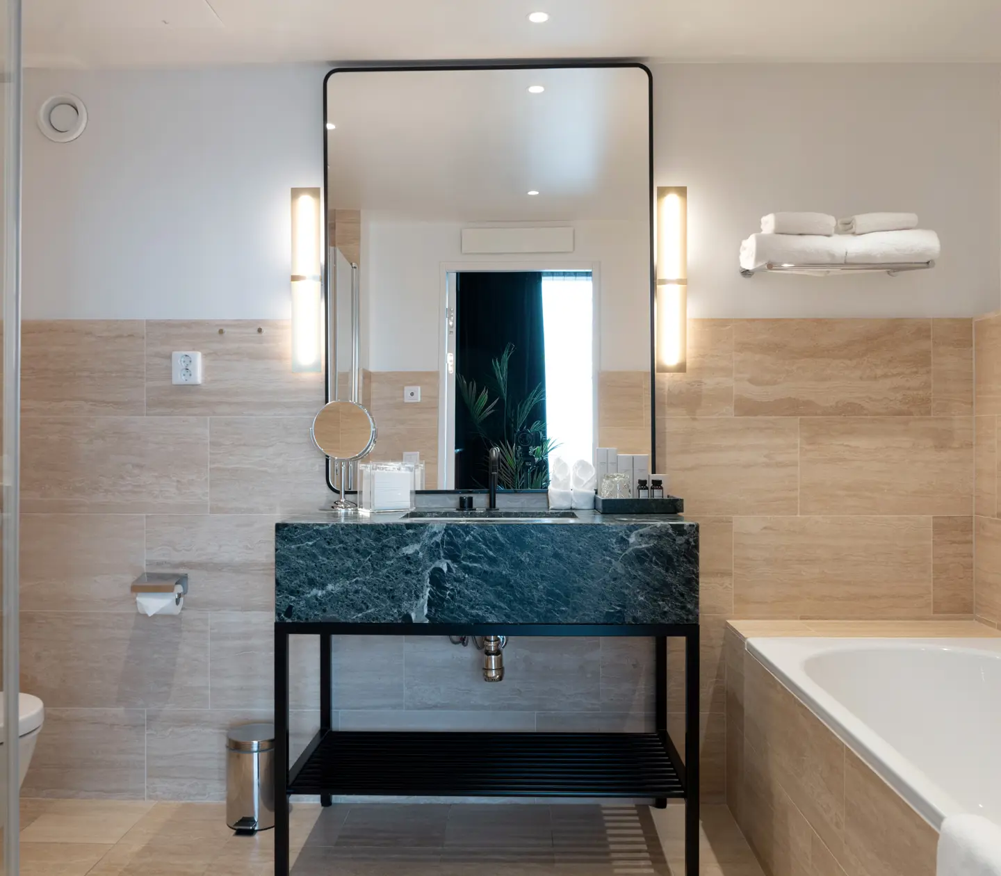 Beige bathroom with bathtub, sink and mirror
