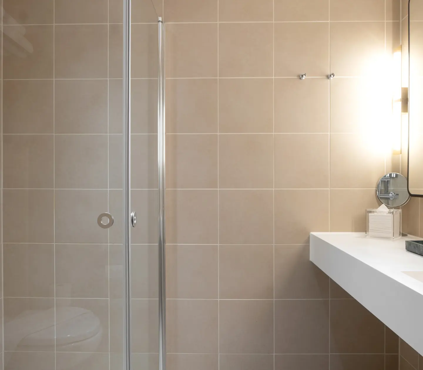 Beige bathroom with shower, sink and mirror