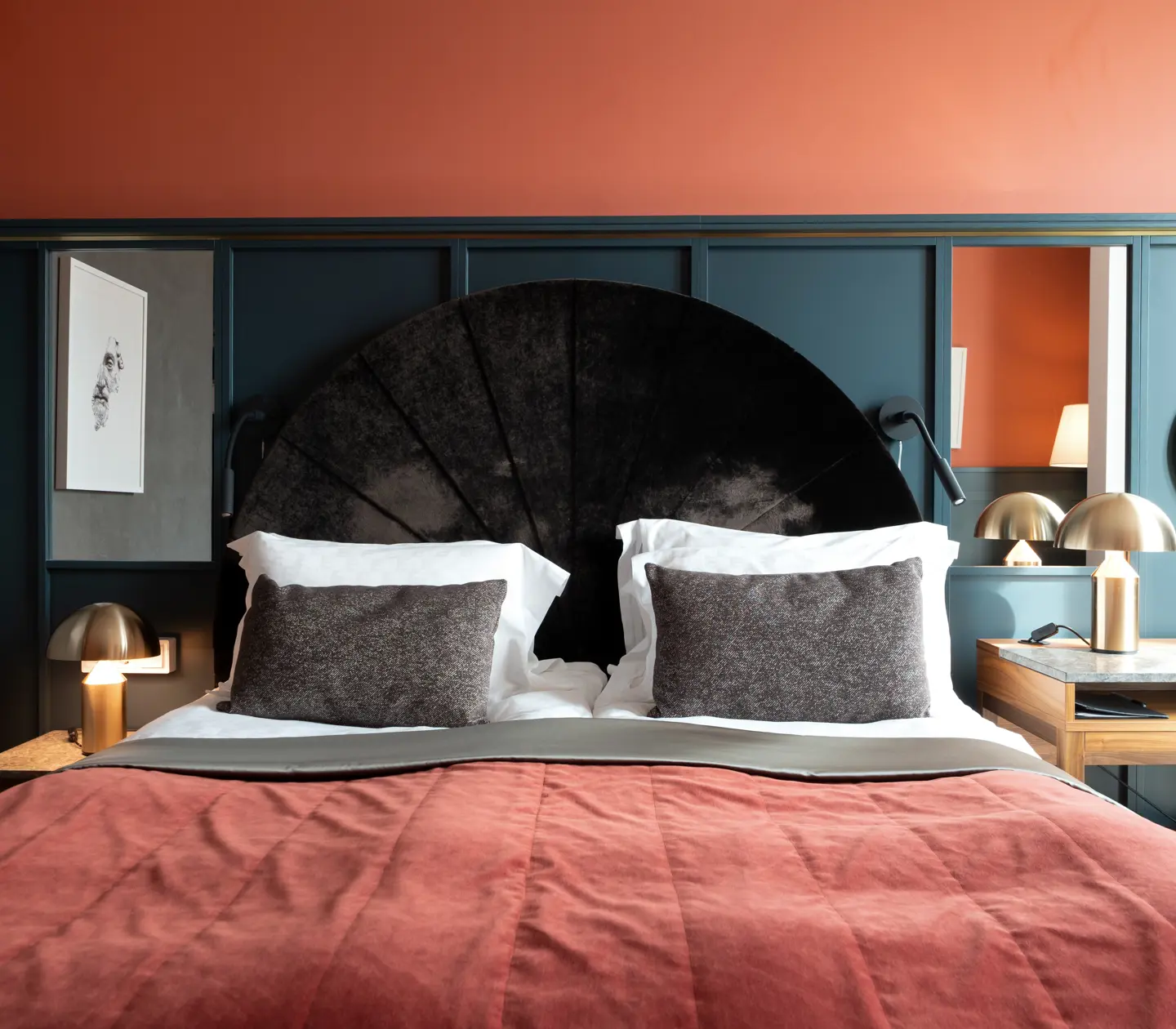 Cozy hotel room with bed, mirrors and desk