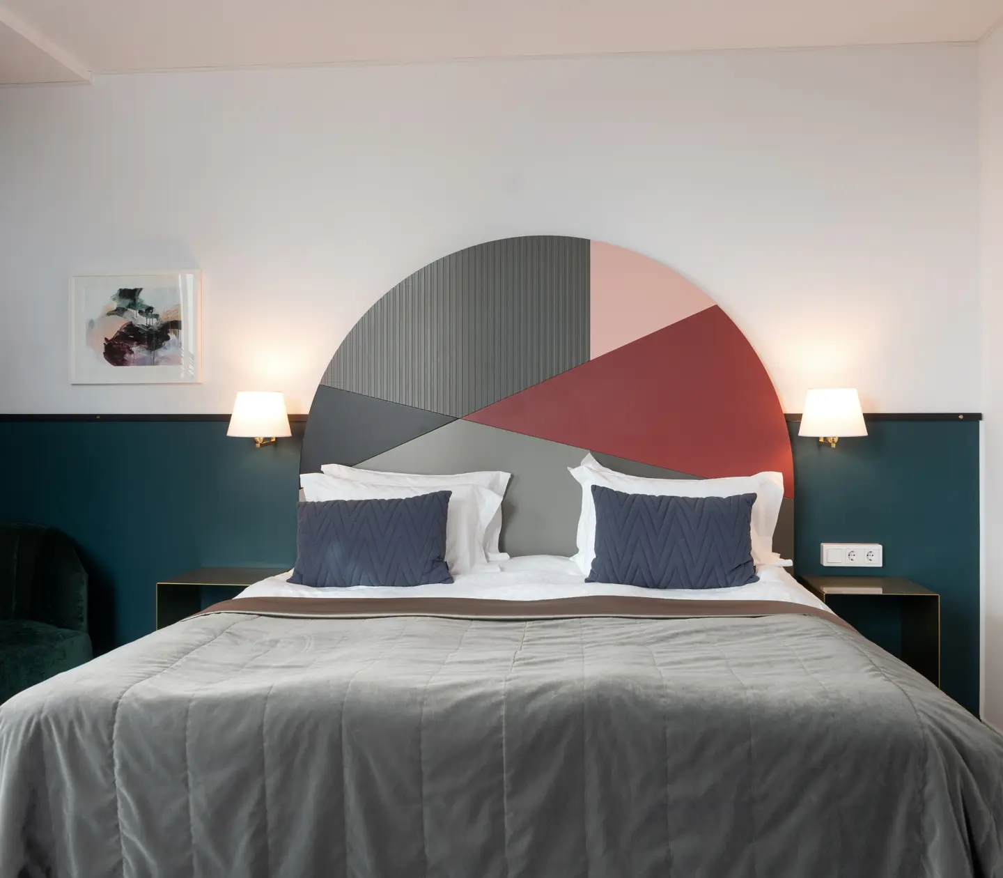 Bright suite with bed, colorful headboard and armchair