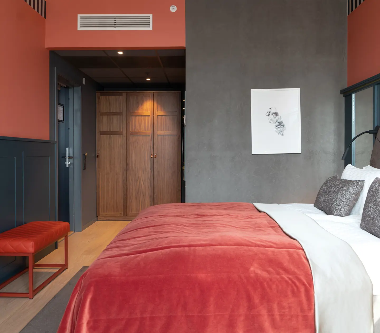 Cozy suite with blue and red wall, bed and bookshelf