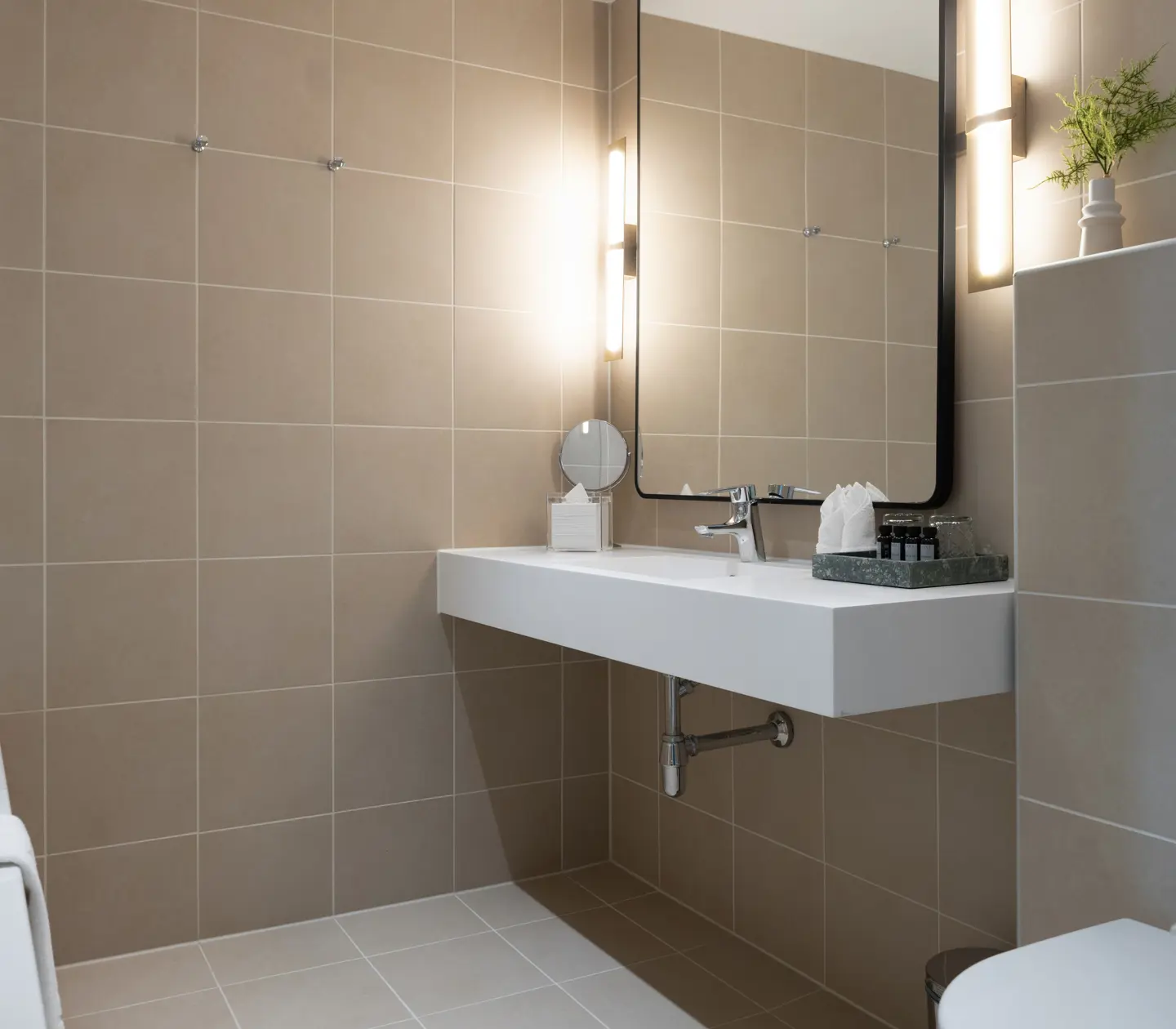 Beige bathroom with bathtub, sink and mirror