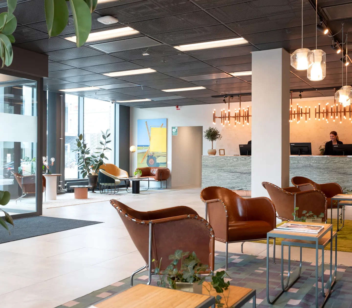 Hotel lobby with reception desk, windows and lounge furniture