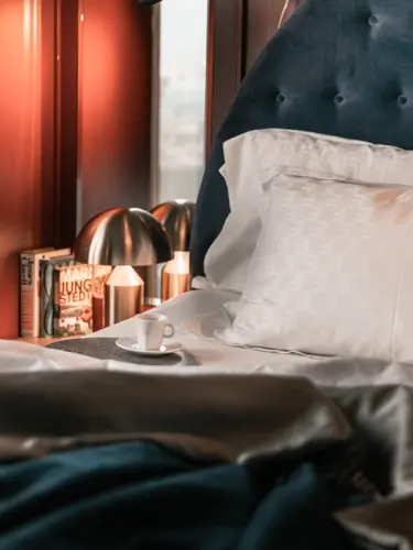 Mysigt hotellrum med dubbelsäng och kaffekopp på sängkanten