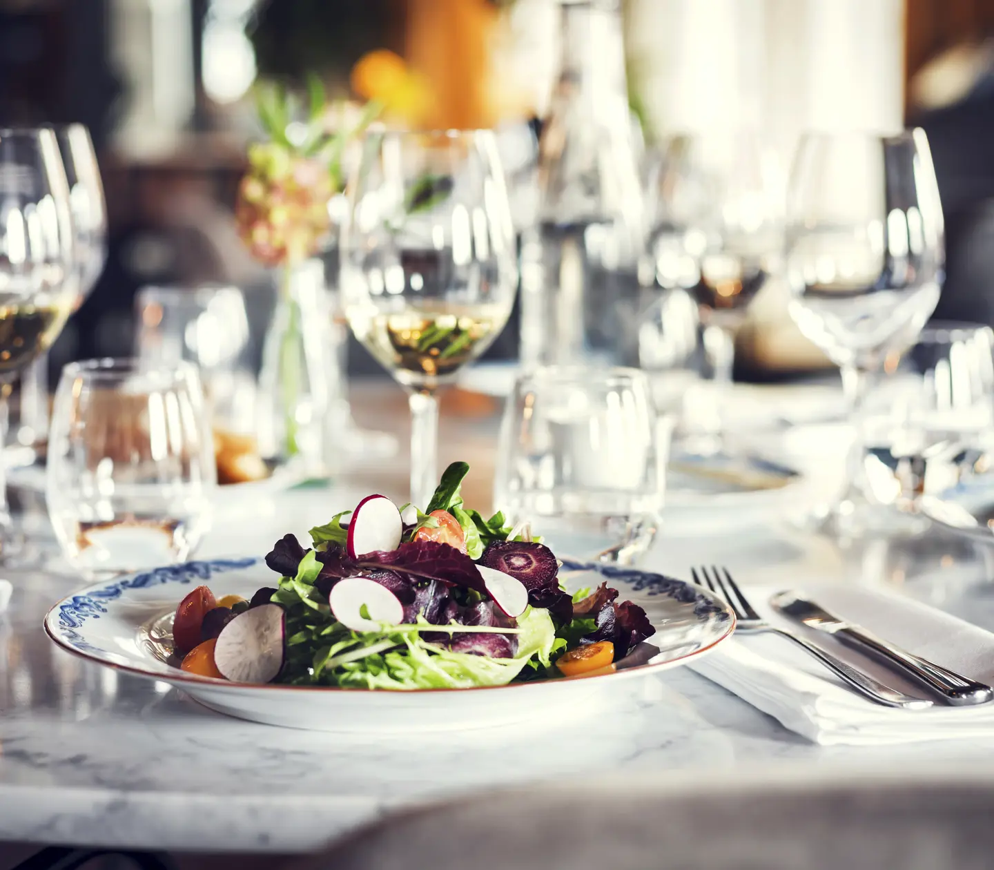 Food served on a plate on a table with more plates and glasses
