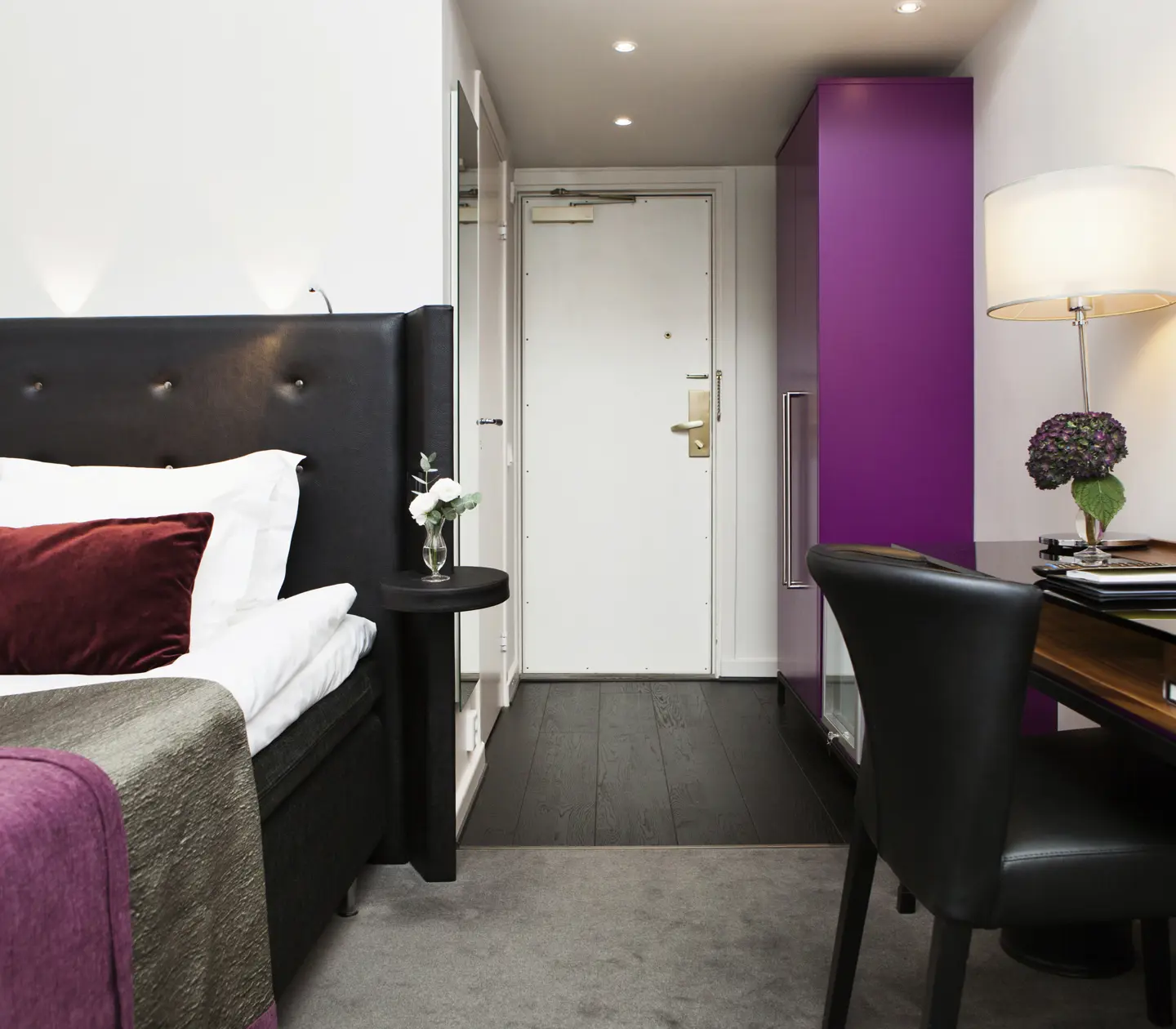 Hotel room with single bed, desk and wardrobe