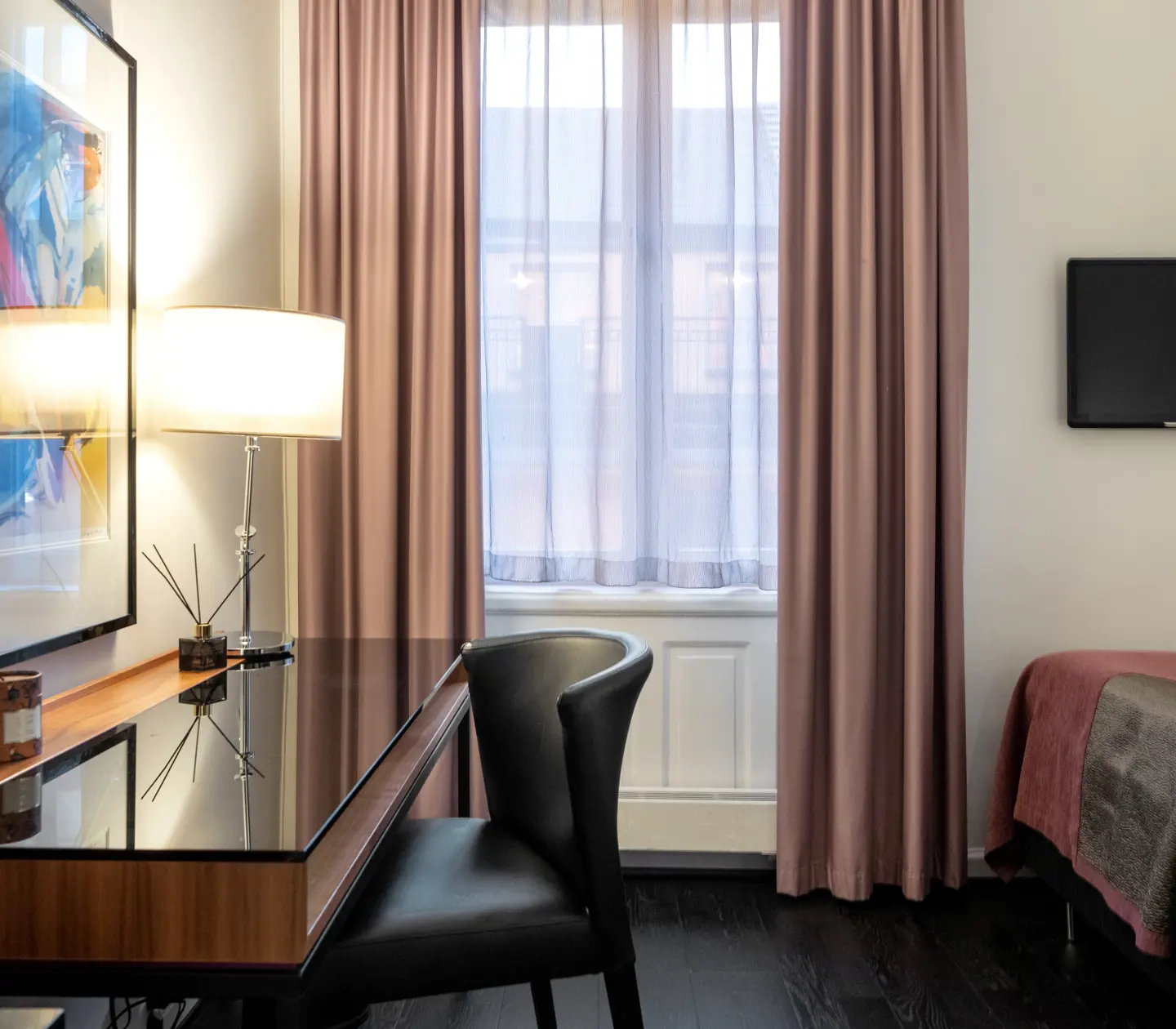 Hotel room with desk, blackboard, single bed, TV and window