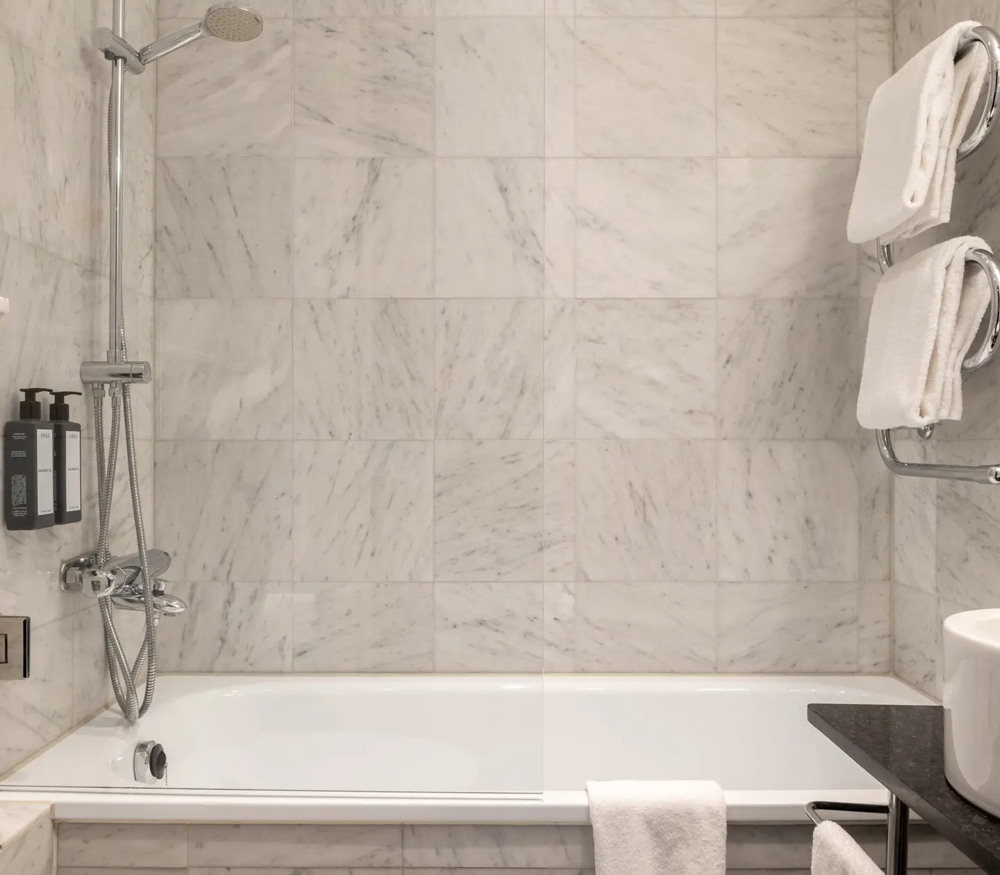 Bright bathroom with bathtub, heated towel rail and sink