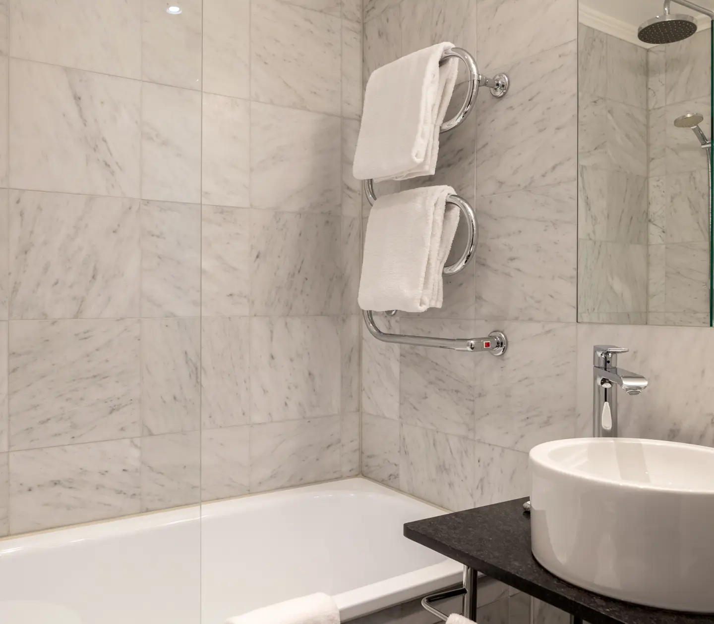 Bright bathroom with mirror, sink and heated towel rail