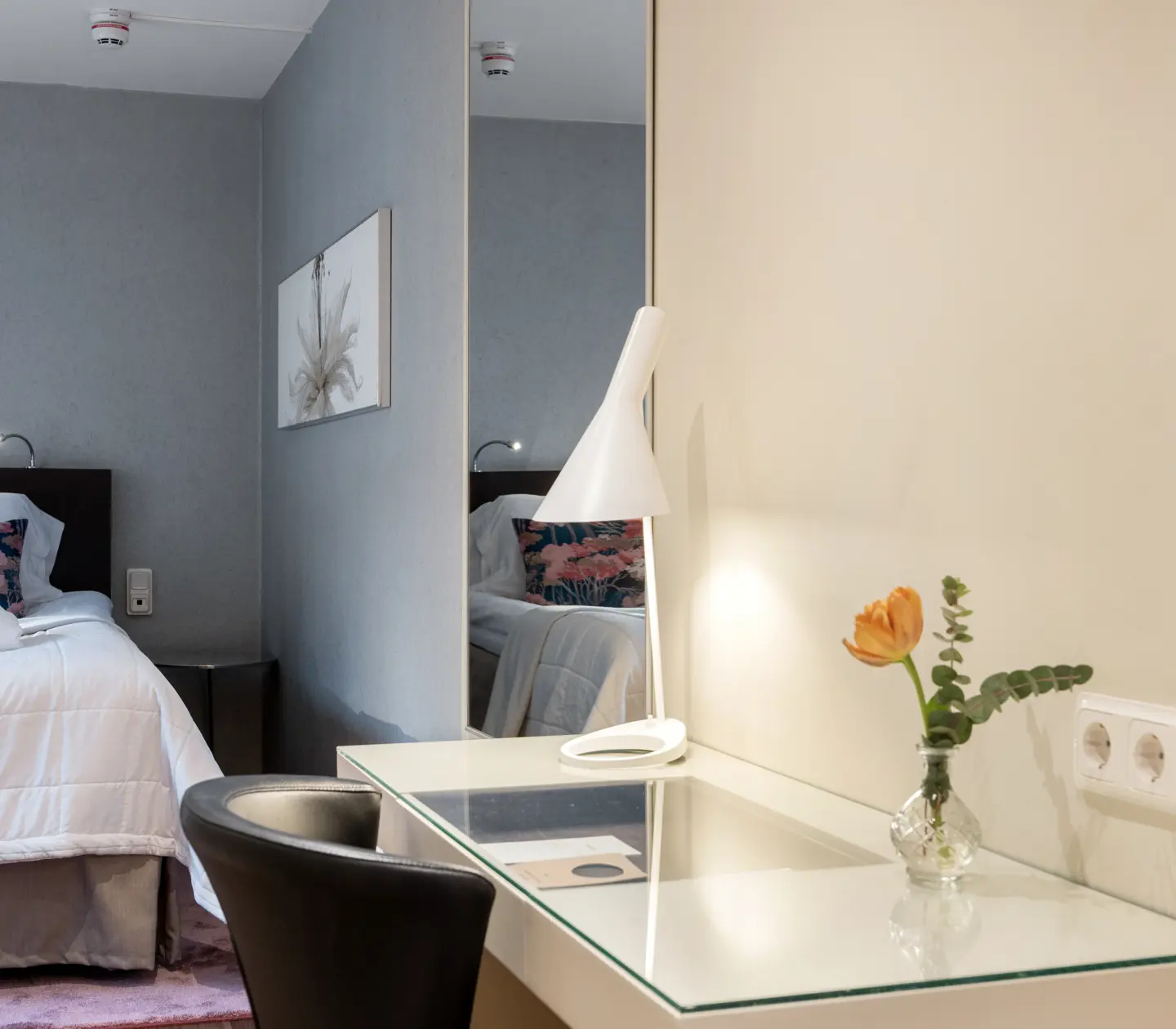 Cozy hotel room with double bed, blackboard, mirror and desk