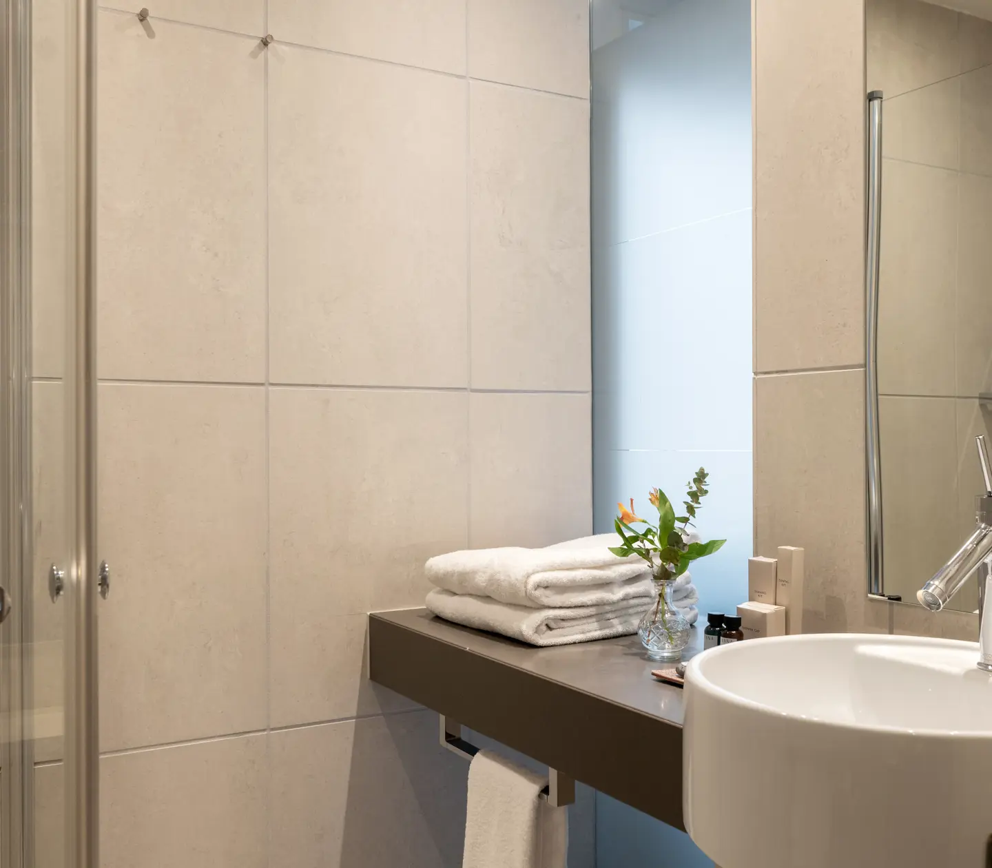Bathroom with shower, sink, mirror and towels
