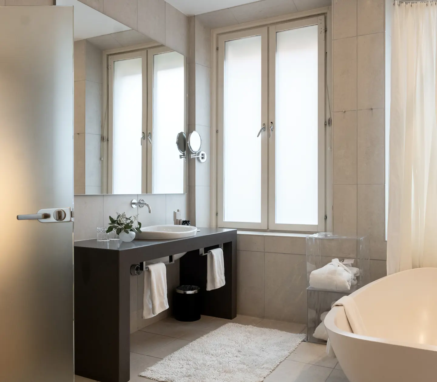 Bright bathroom with sink, mirror, window and egg-shaped bathtub